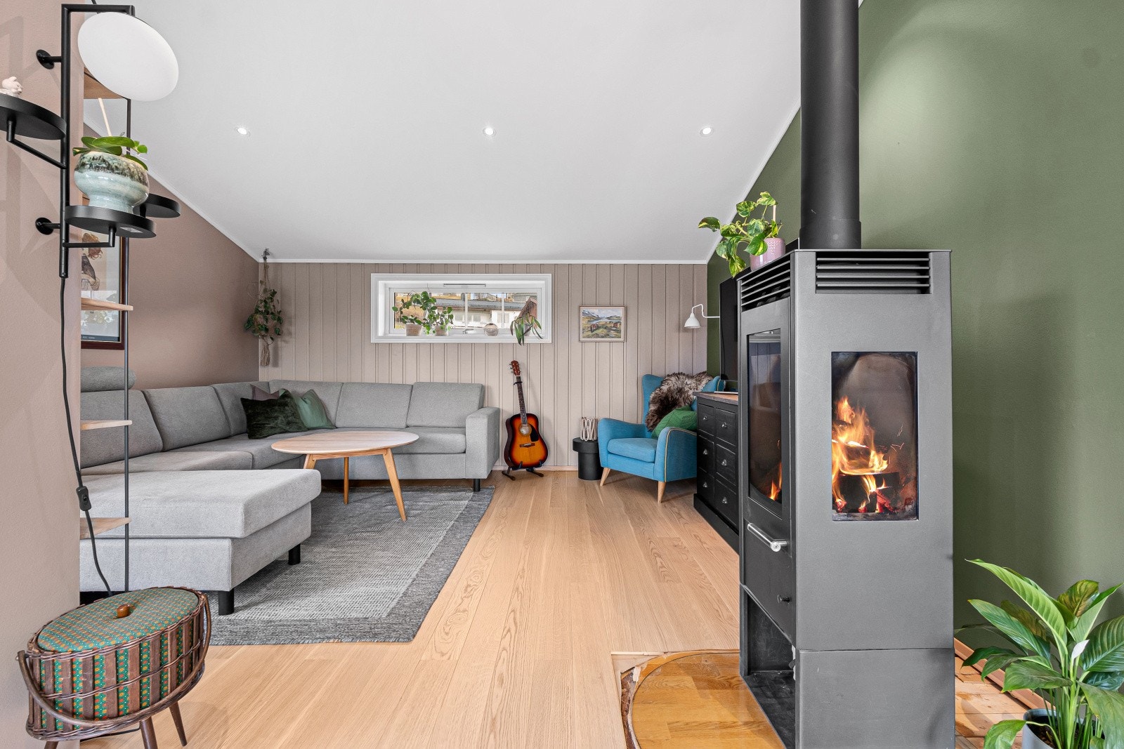 Stuen har god plass til en romslig sofagruppe, og vedovnen tilfører ekstra komfort. Galleribilde