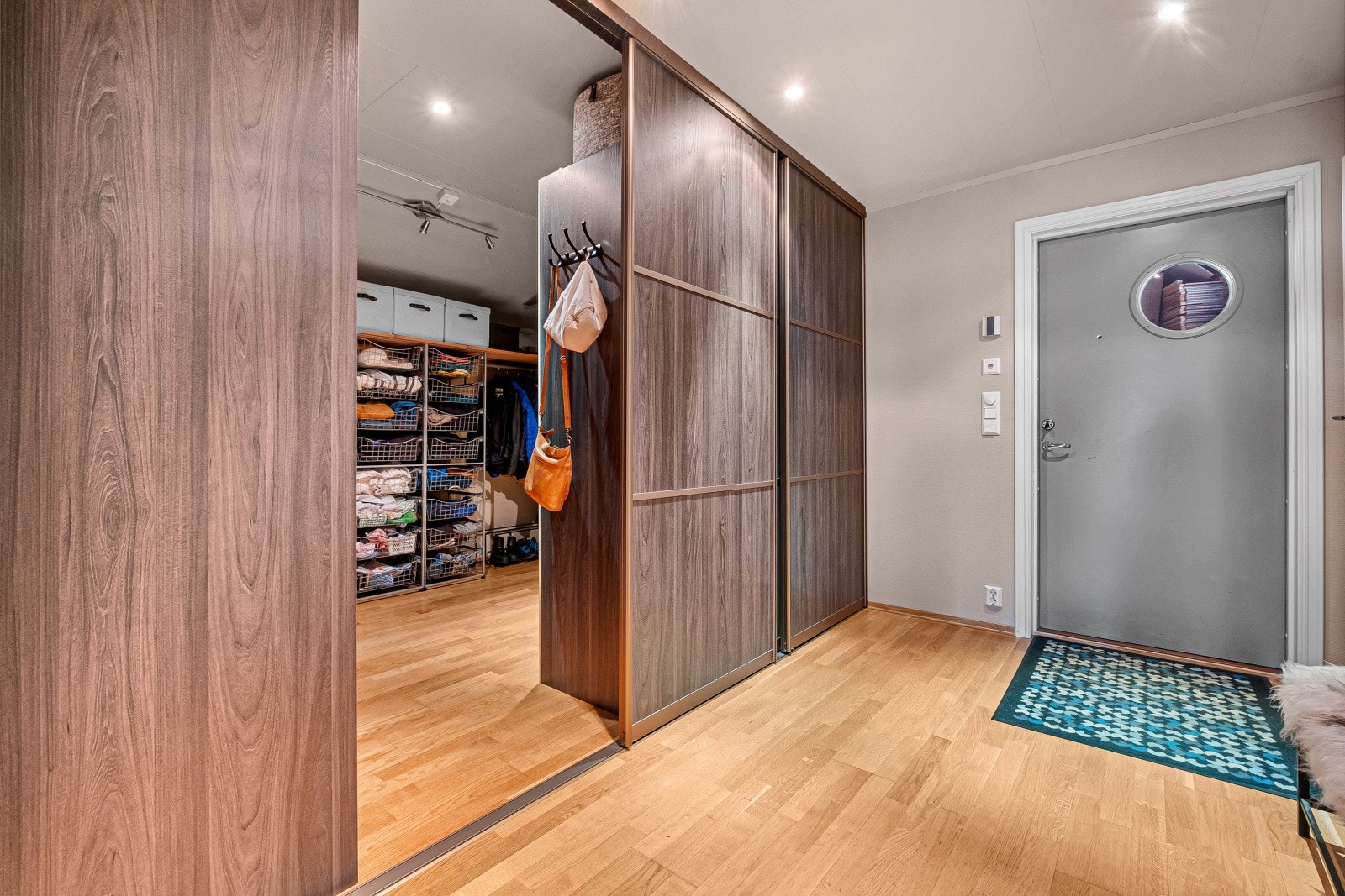 Romslig entré med gode oppbevaringsmuligheter i en stor skyvedørsgarderobe. Galleribilde