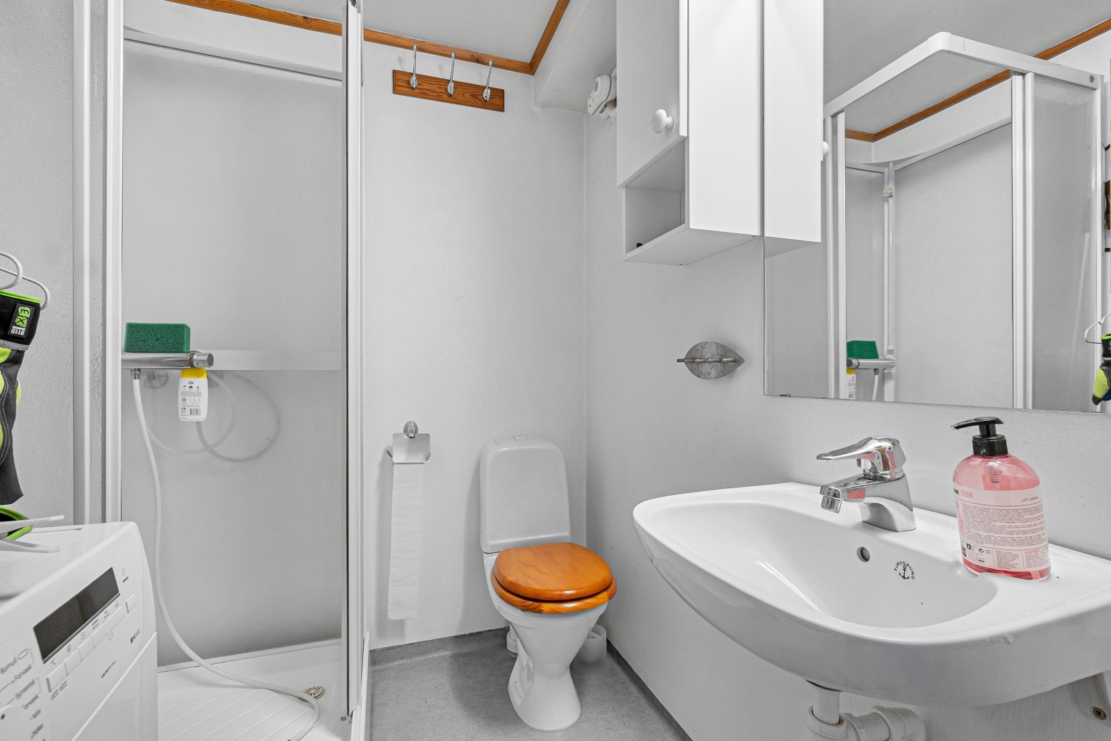 Videre har enheten et eget bad med vinylbelegg på gulvet, utstyrt med dusjkabinett og opplegg for vaskemaskin. Badet er innredet med servant, speil og skap. Galleribilde