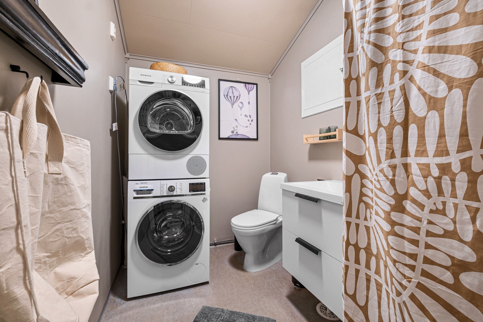 Det er også et vaskerom i denne etasjen er innredet med baderomsinnredning med servant, gulvstående toalett og opplegg for vaskemaskin. Galleribilde