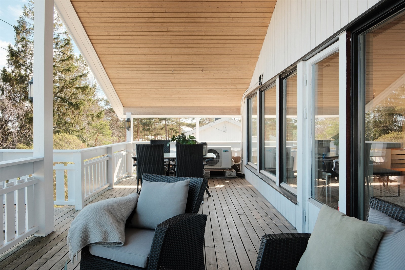 Sommerstid er det morgen- og formiddagssol på den store verandaen. Under takutstikket er det lunt og hyggelig også på lyse sommerkvelder. Galleribilde