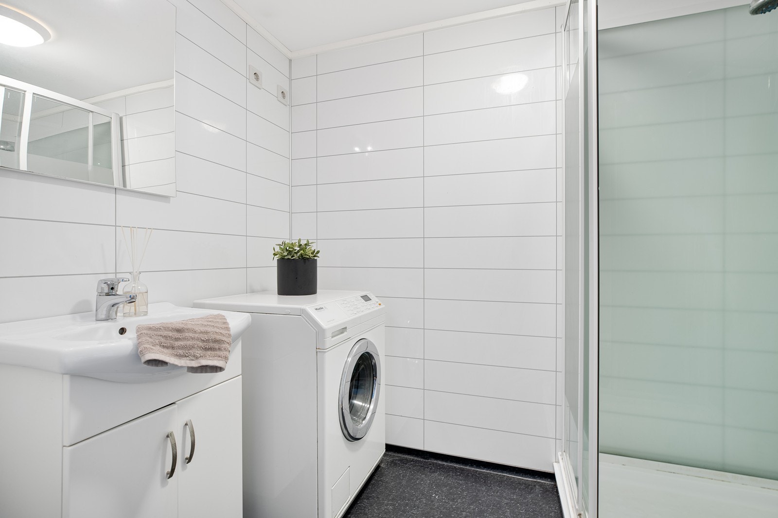 Pent flislagt bad innredet med nedfelt servant, dusjkabinett og toalett Galleribilde