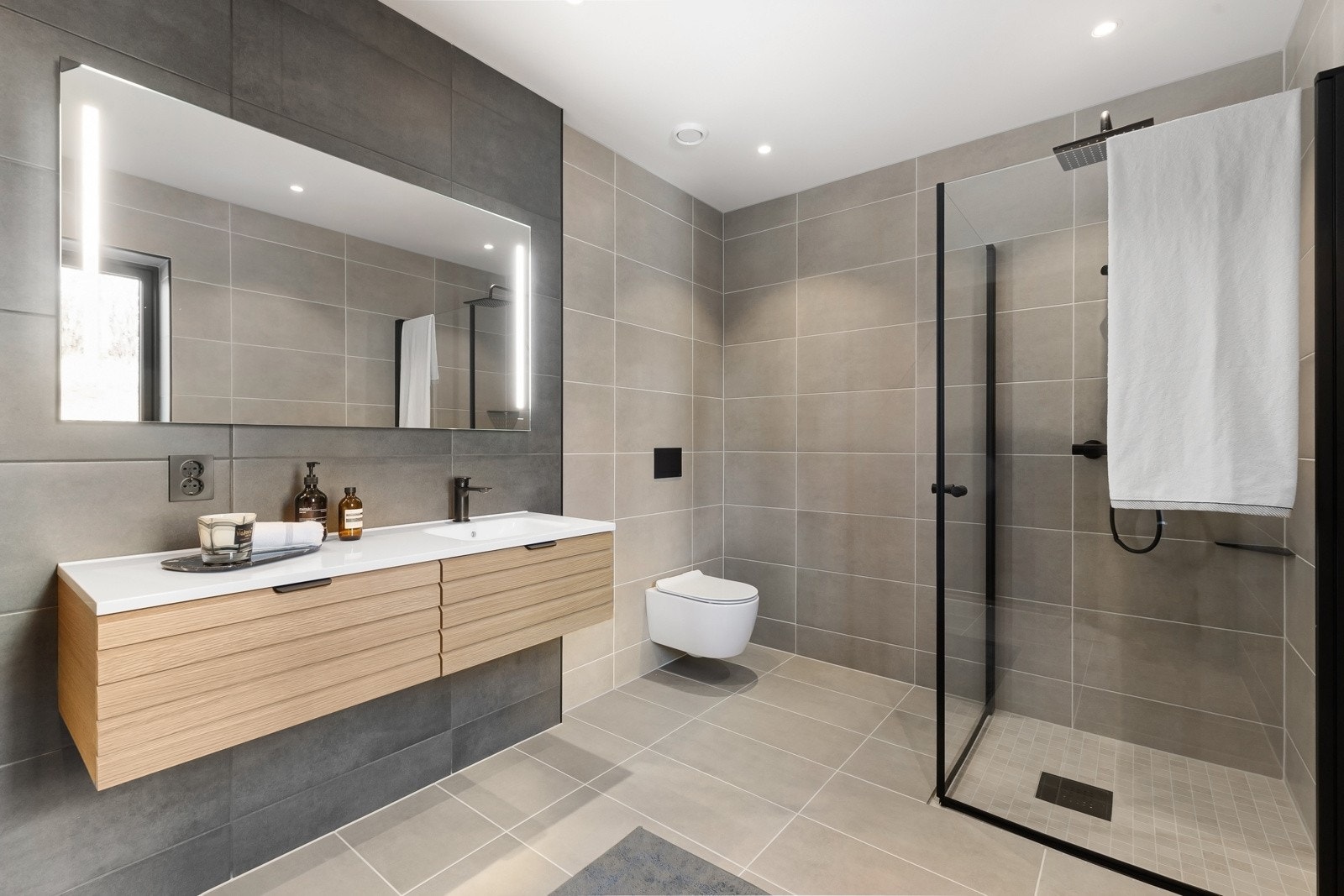 Badet har tidløse fliser og moderne, svarte detaljer. Galleribilde