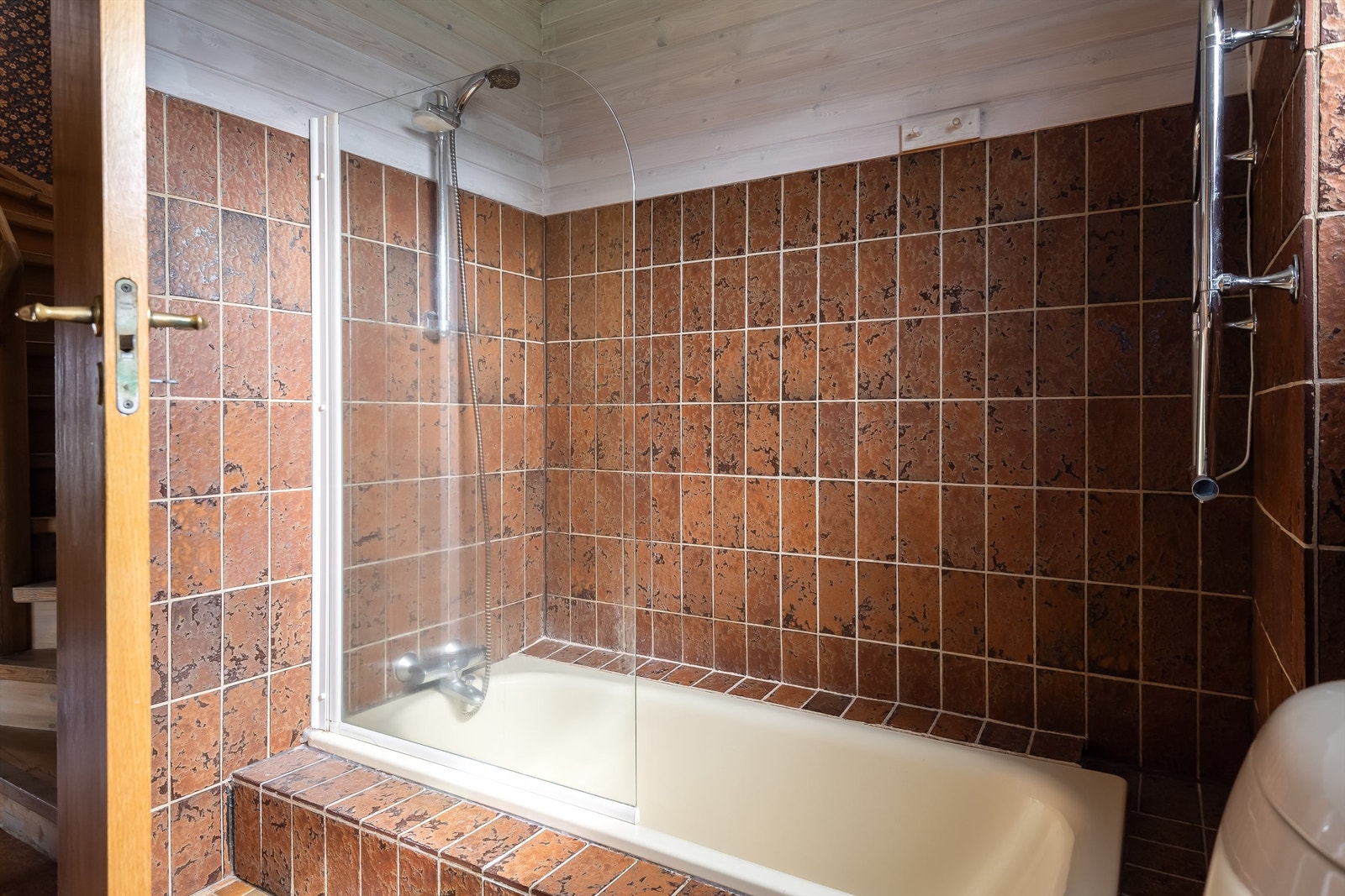 Videre er badet utstyrt med servantskap med overskap og speil med lys, toalett og badekar med vegghengt dusjarmatur. Galleribilde