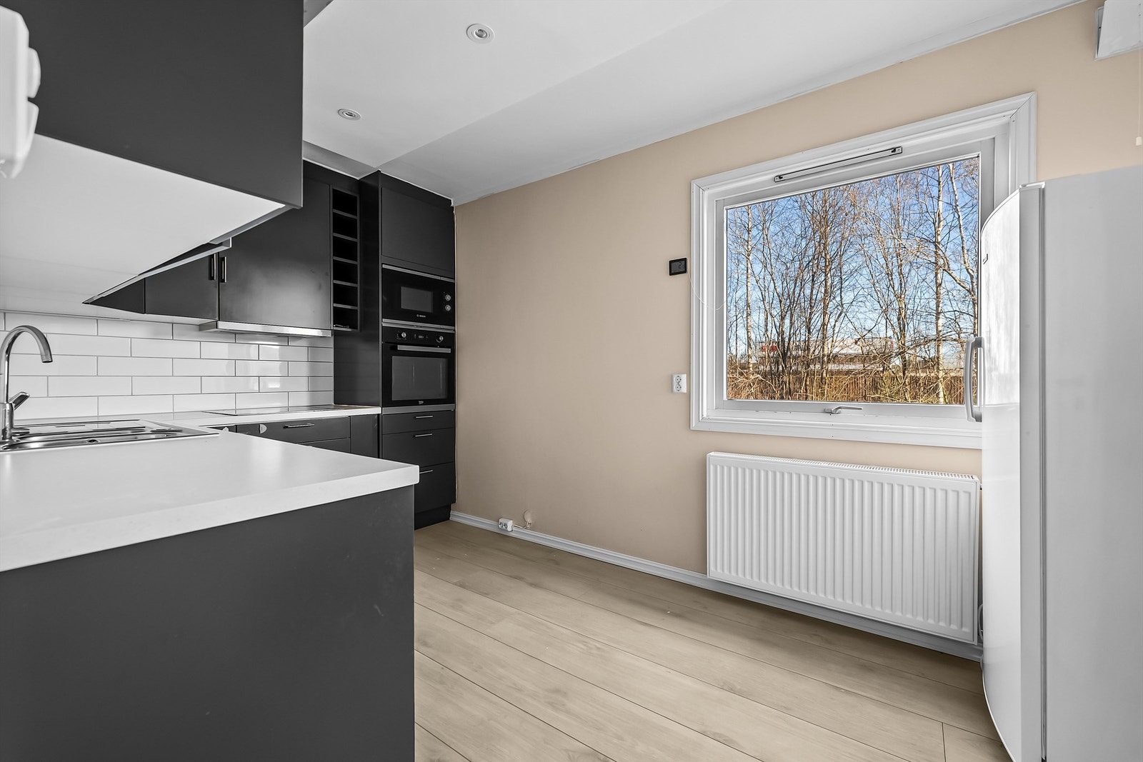 Kjøkkenet har malt himlingsflate med nedsenket kasse for downlights. Galleribilde