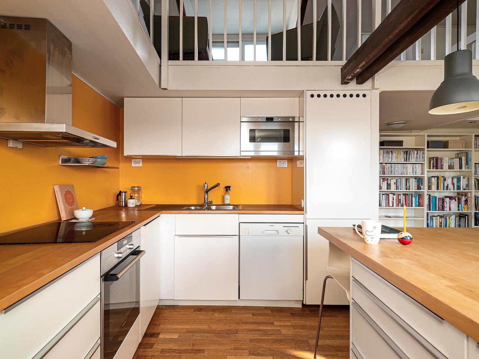 Kjøkken utstyrt med integrerte hvitevarer som platetopp og stekeovn, samt kombinert kjøleskap/fryser og oppvaskmaskin. Galleribilde