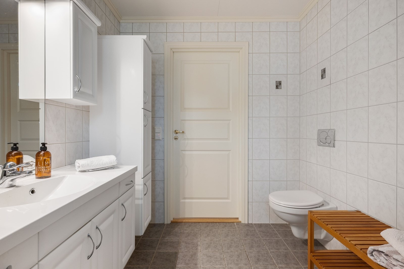 Badet har vegghengt toalett og dusjkabinett. Plass til tilleggsmøbler enten for oppbevaring eller sittebenk. Galleribilde