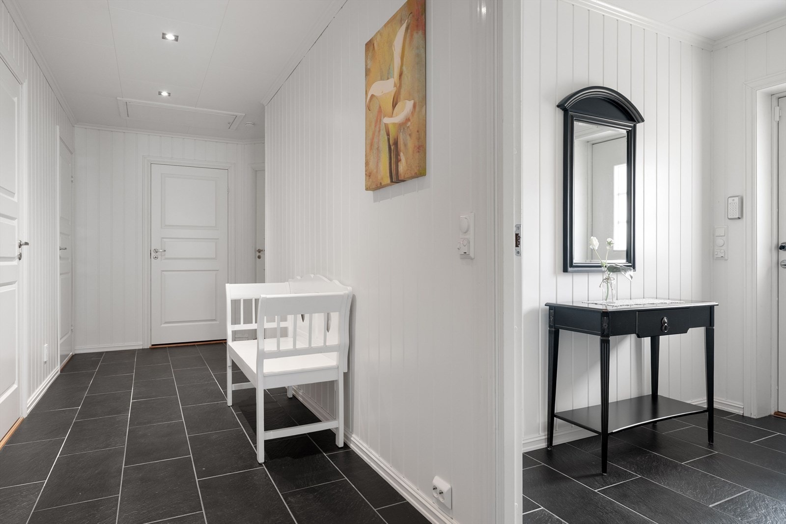 Adkomst fra entré til mellomgang med tilgang til resterende rom i boligen. Her også flislagt gulv. Adkomst til loft via luke i himling. Galleribilde