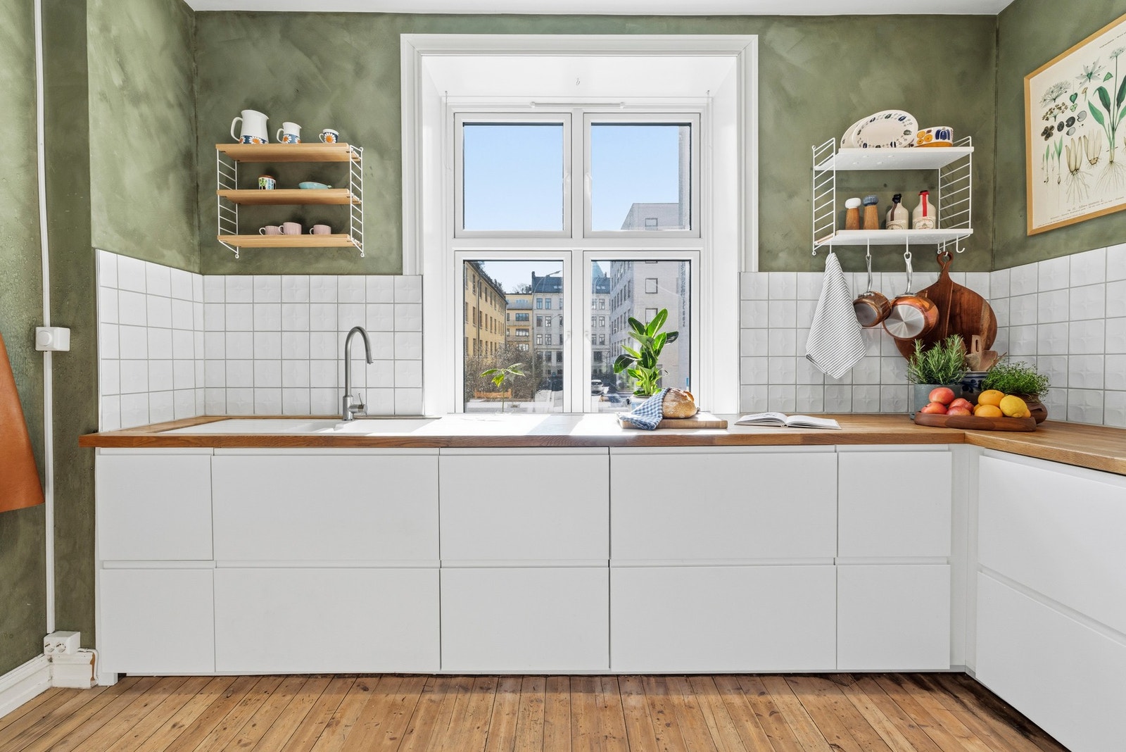 Kjøkkeninnredning fra 2016 med hvite grepsfrie fronter og fliser på vegger Galleribilde