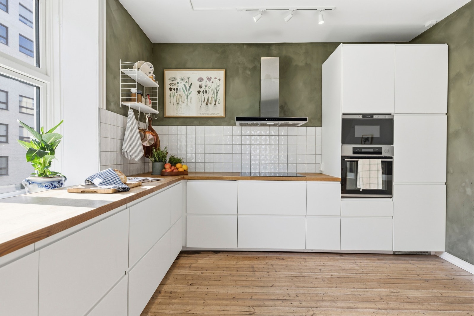 Tidløst kjøkken med integrerte hvitevarer som oppvaskmaskin,
induksjonsplatetopp, micro og stekeovn med dampfunksjon i
høyskap og kjøleskap samt veggmontert avtrekksvifte Galleribilde