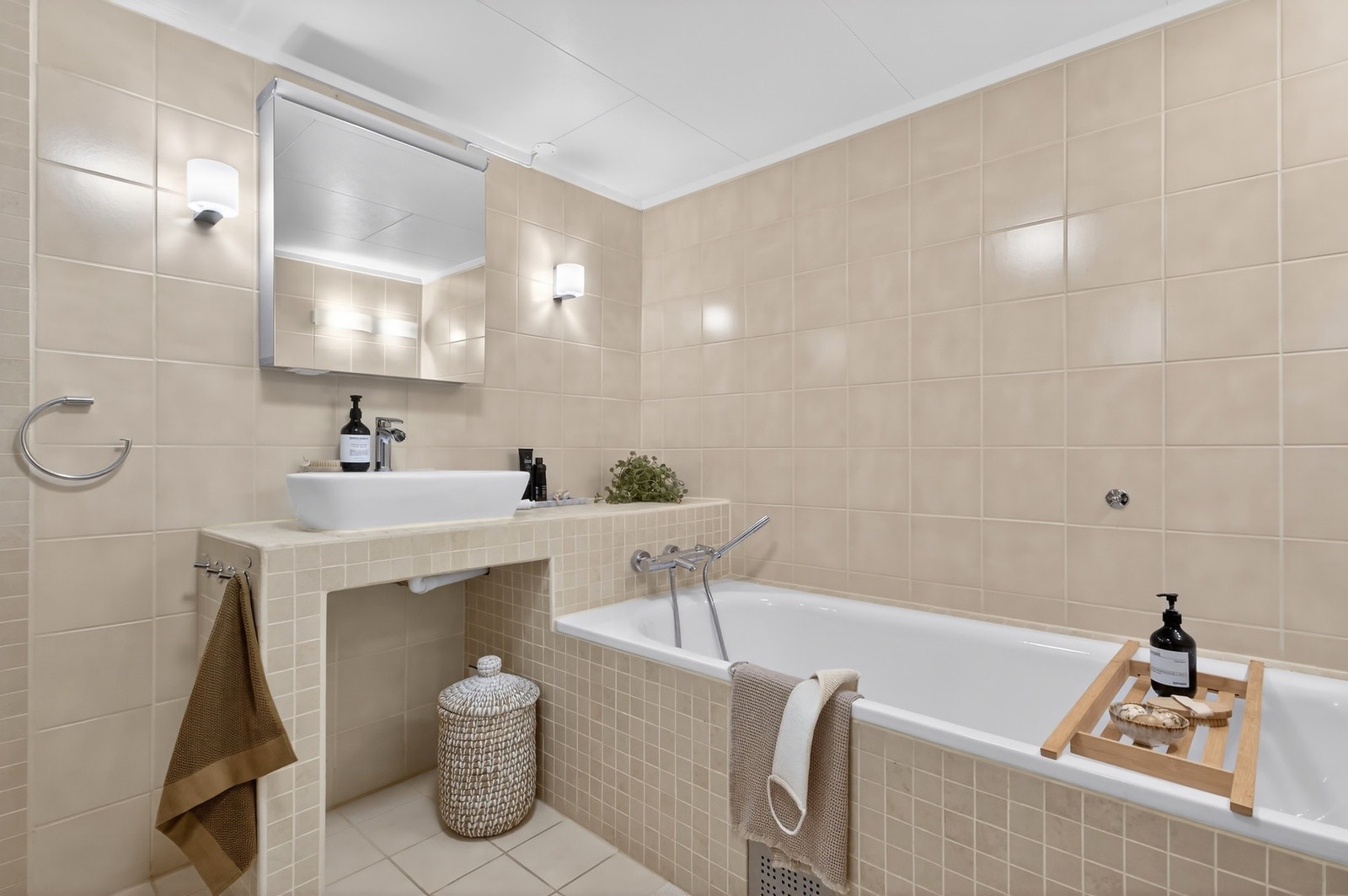 Flislagt baderom med elektriske varmekabler i gulv som gir god komfort. Badet har innredning med nedfelt servant, toalett og badekar. Rommet har elektrisk styrt vifte. Galleribilde