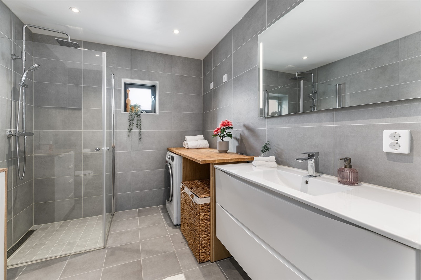 Badet er smart innredet til kombinert formål som vaskerom. Dusjdørene kan svinges inn for enklere tilgang til vaskemaskinen. Galleribilde