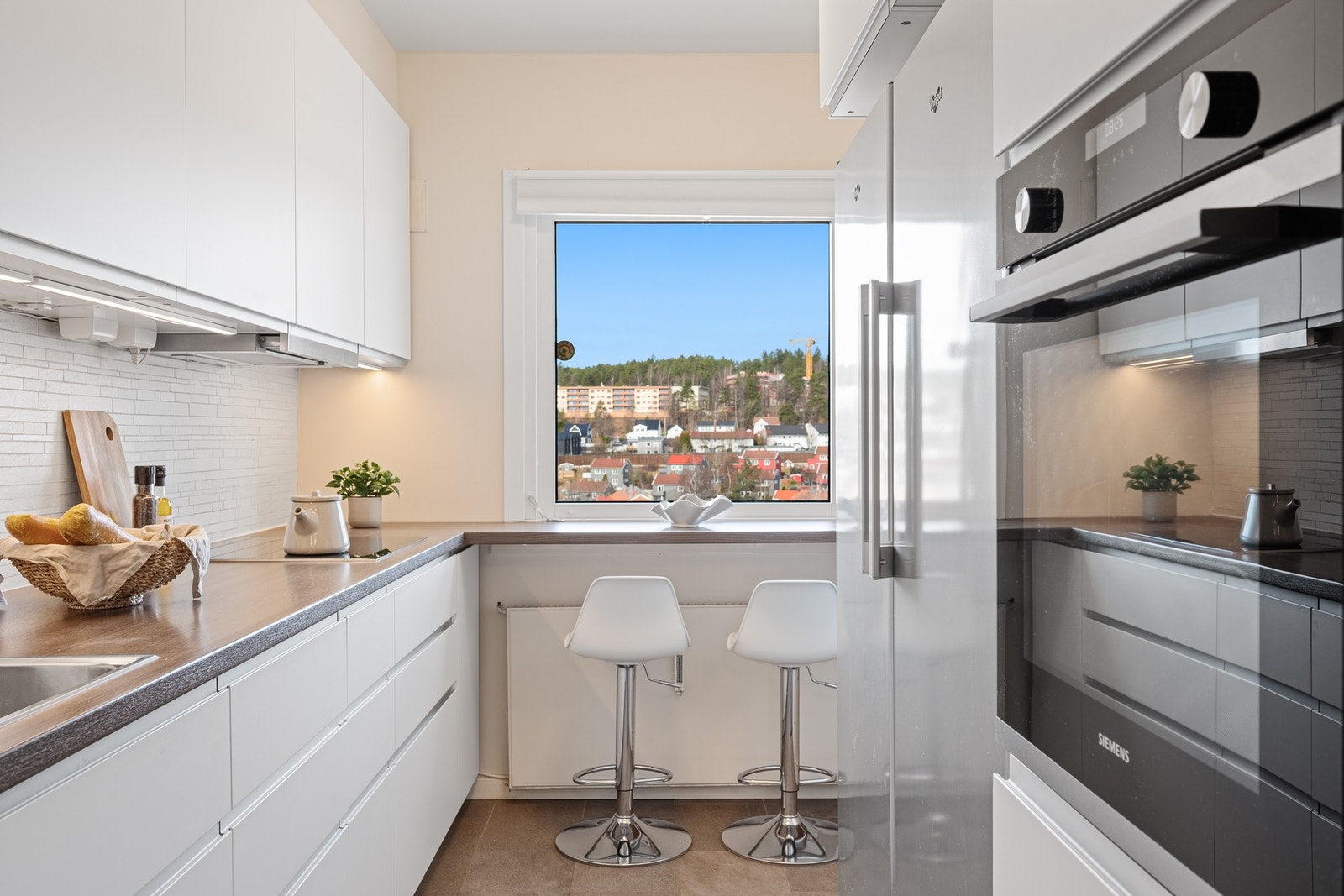 Her finner du integrerte hvitevarer som oppvaskmaskin, induksjonstopp og stekeovn, mens kjøleskap og fryseskap er plassert frittstående for fleksibel bruk. Galleribilde