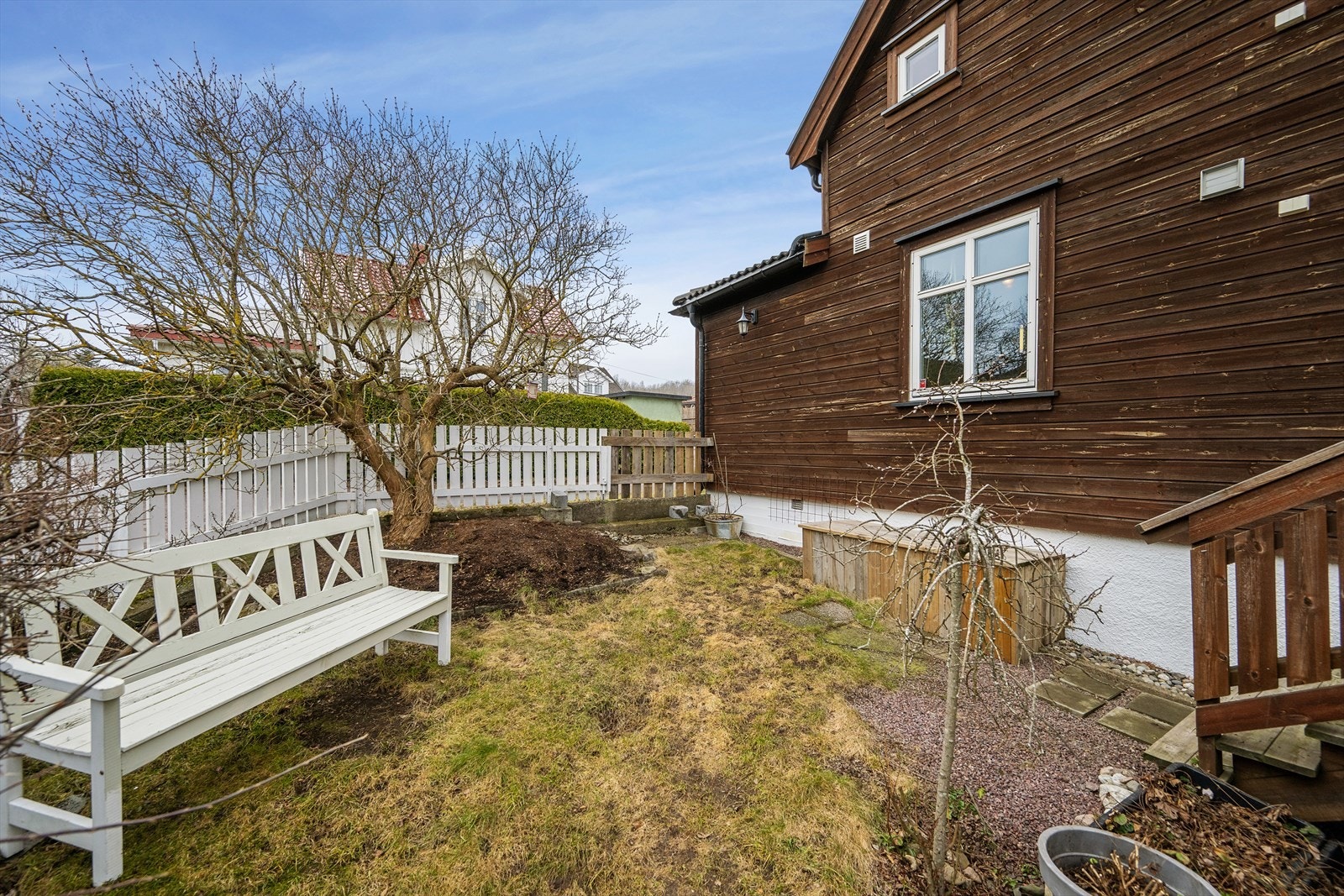 Terrassen har trapp ned til bakkeplan. Opparbeidet hage med staudebed, prydtrær og gressplen. Galleribilde