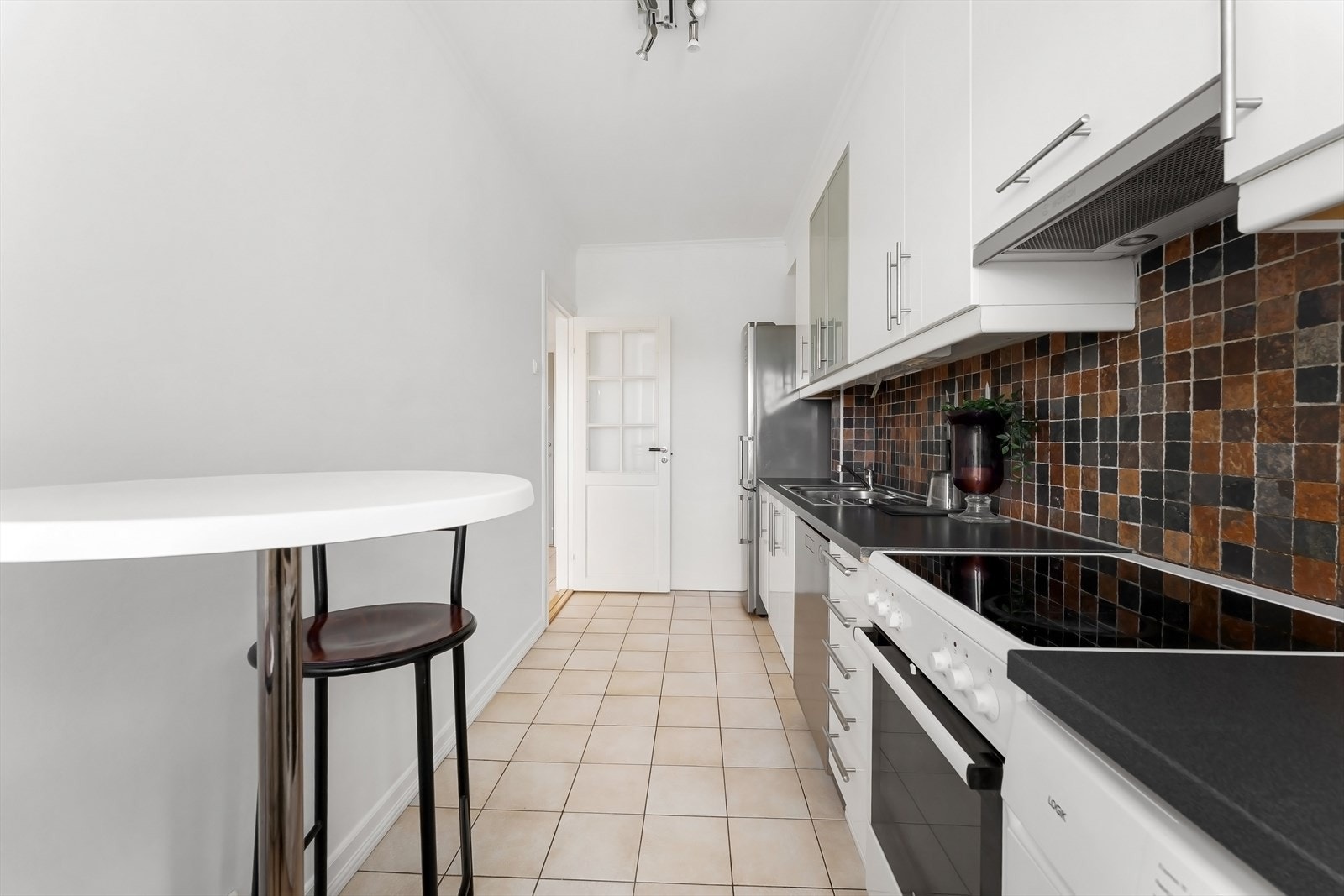 Kjøkkeninnredning fra IKEA med glatte fronter og laminat benkeplate. Galleribilde