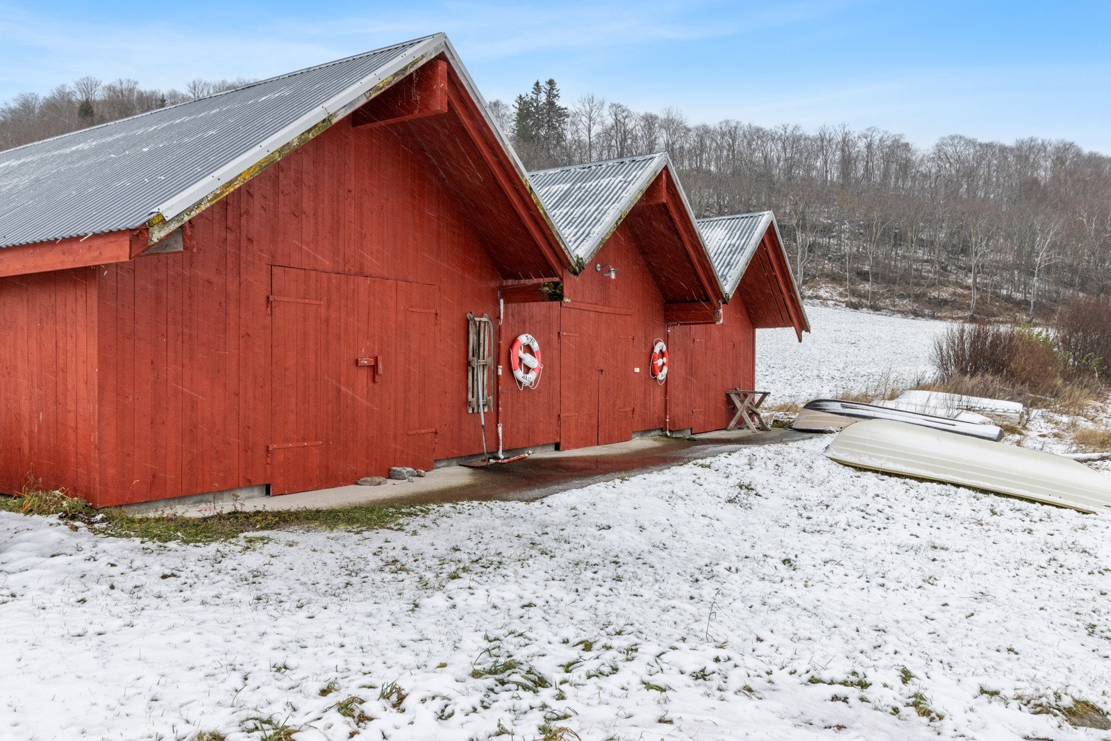 Kun kort veg fra gårdstunet disponerer eiendommen et naust (midten). Galleribilde