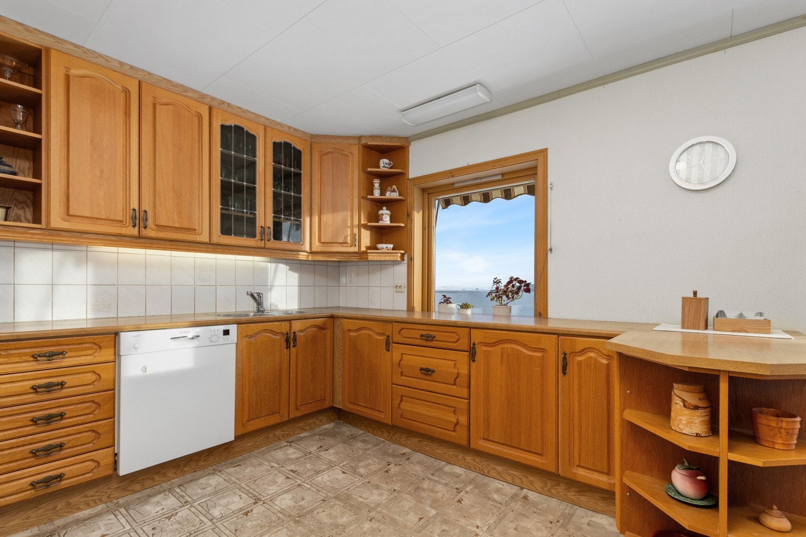 Romslig kjøkken med takhøye skap. Kjøkkenet har godt med skap- og benkeplass. Nydelig utsikt. Galleribilde