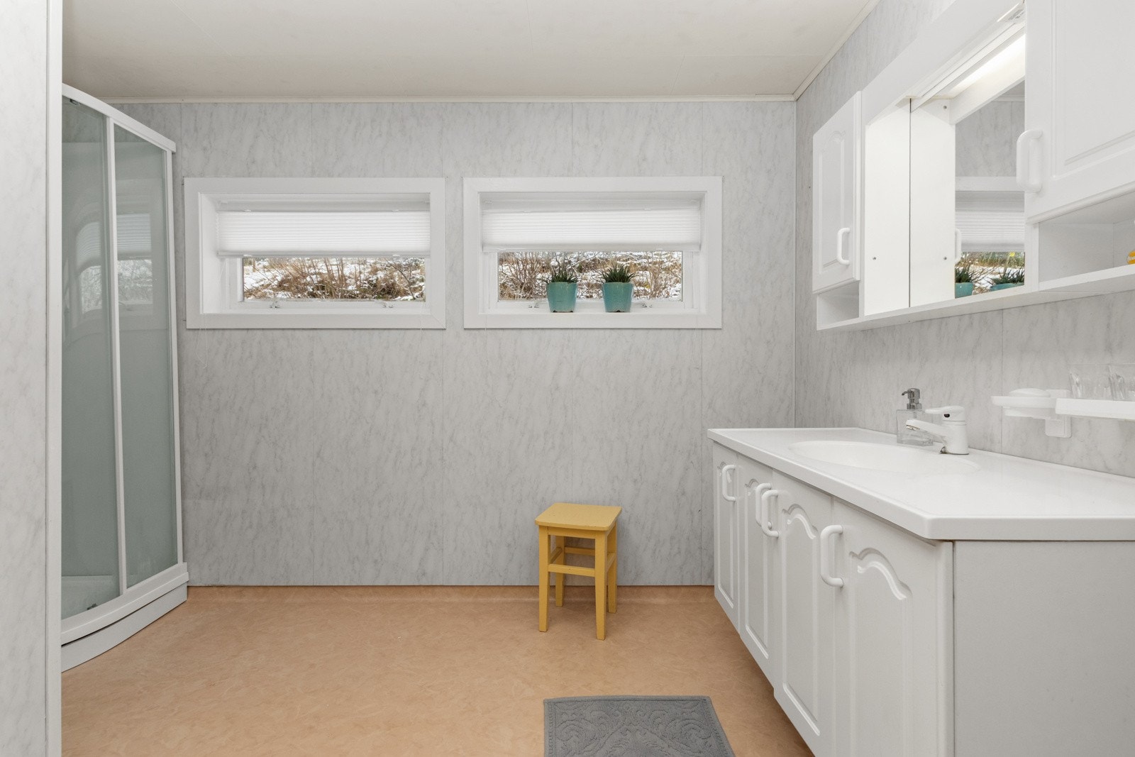 BRomslig bad med baderomsinnredning og dusjkabinett. Galleribilde