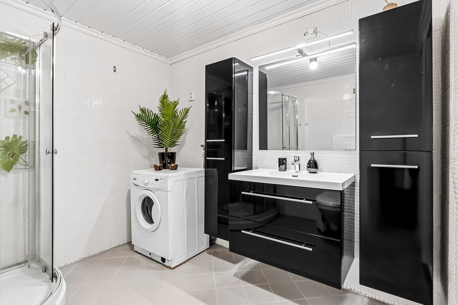 Rommet har innredning med servant, toalett, dusj m/glassdører og opplegg for vaskemaskin. Under servanten er det montert benkeskap med glatte fronter, samt et veggskap. Det er elektrisk styrt vifte. Galleribilde