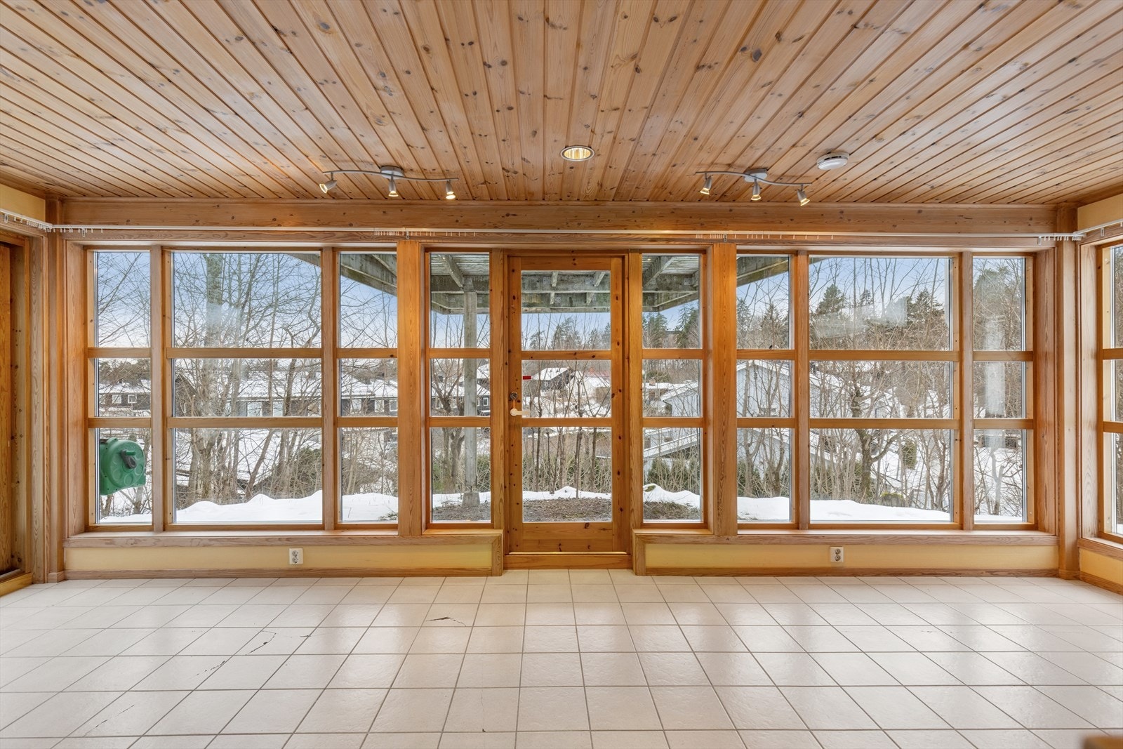 Rommet oppleves lyst og luftig takket være en hel vegg med store vinduer, som slipper inn rikelig med dagslys og gir flott utsyn mot utearealene. Galleribilde