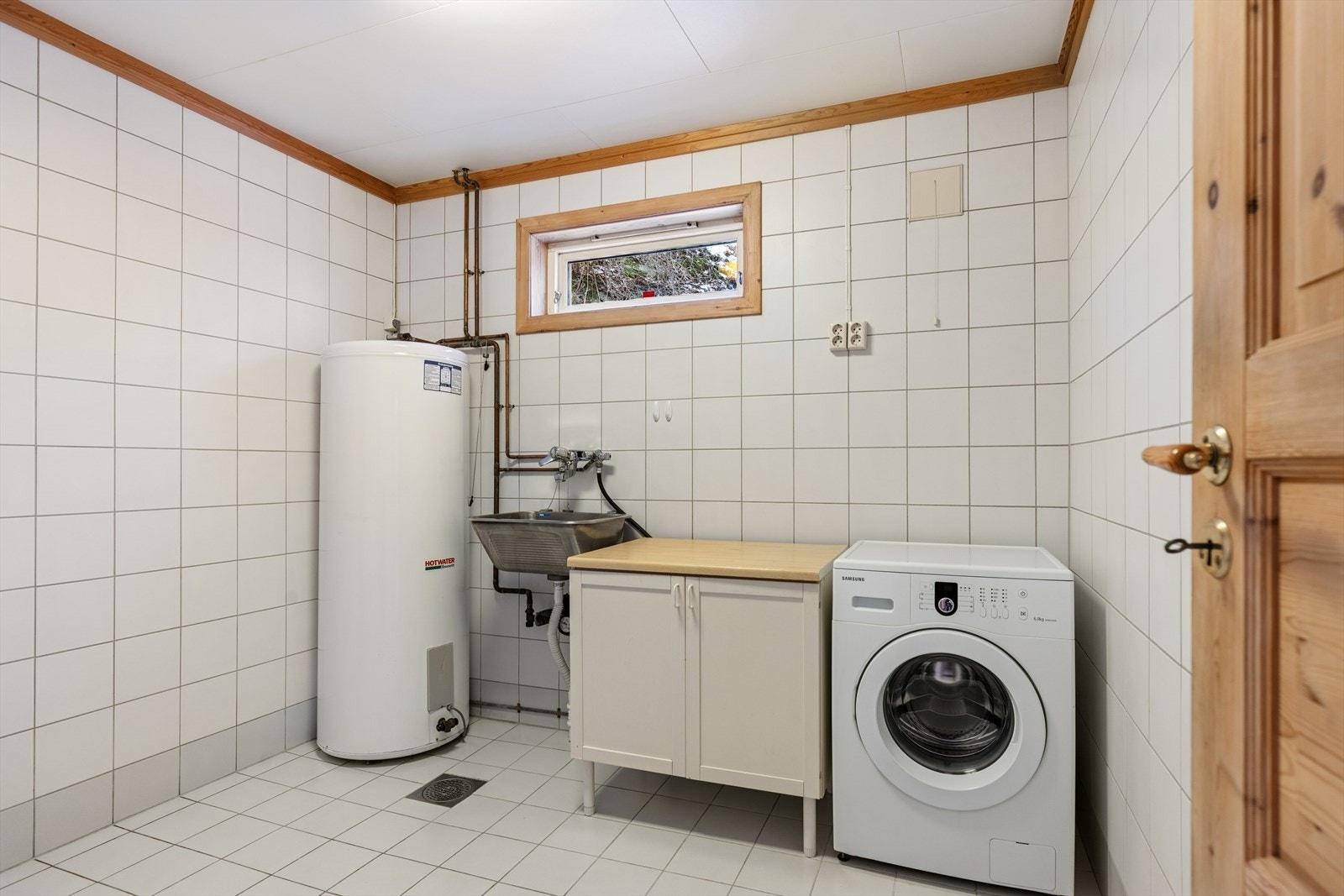 Vaskerommet, antatt fra byggeåret 1990, fremstår som et praktisk og funksjonelt rom med gode arbeidsforhold. Galleribilde