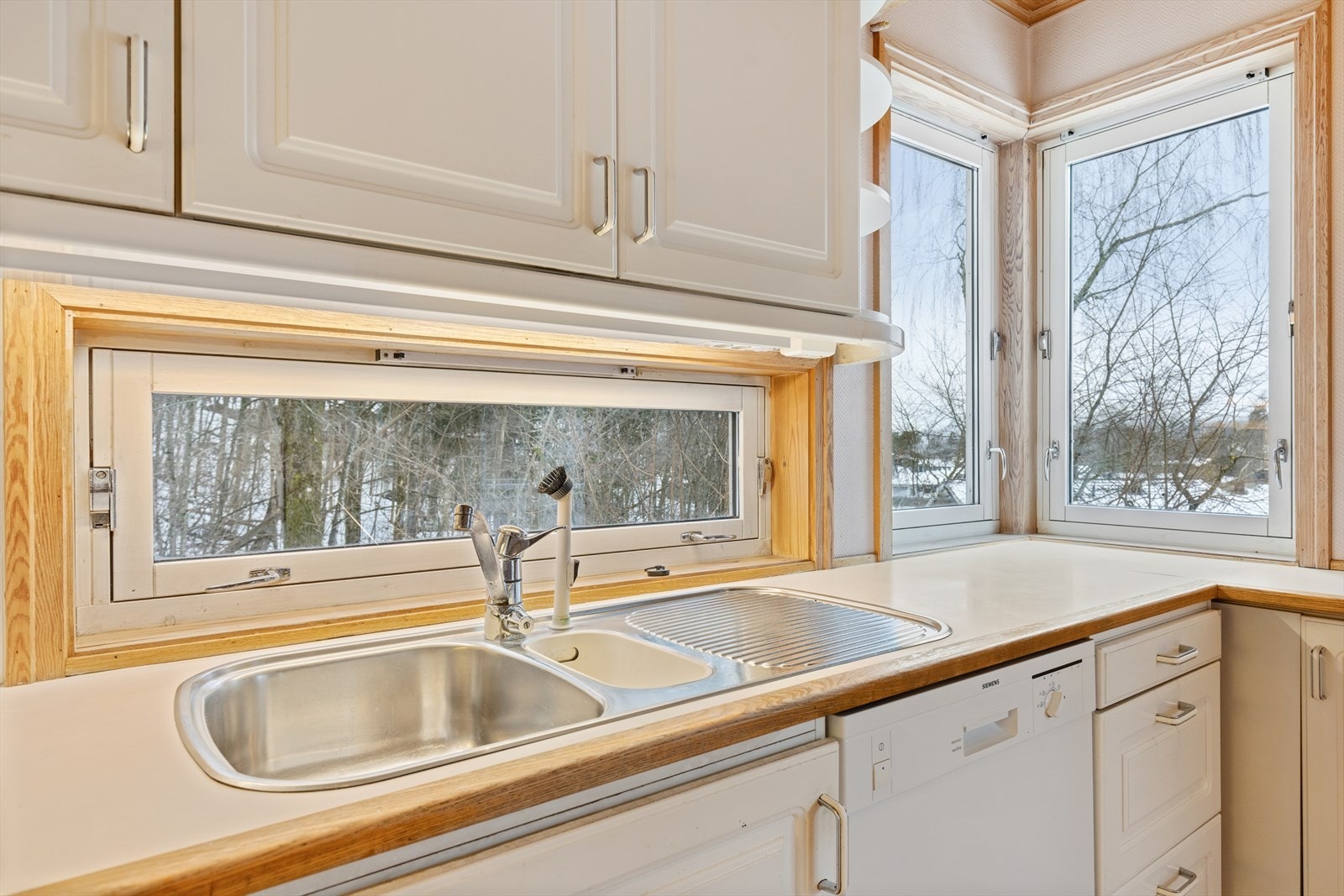 Benkeplaten i laminat er utstyrt med en underlimt dobbel vask, som gjør rengjøring og håndtering av oppvask praktisk og oversiktlig. Galleribilde