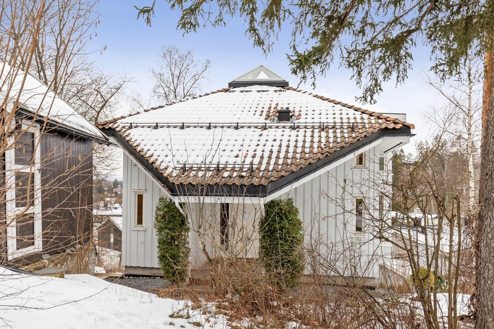 Inngangspartiet er pent overbygget og utformet og gir et godt førsteinntrykk. Den praktiske markplattingen sørger for en jevn og solid adkomst, samtidig som overbygget gir effektiv beskyttelse mot vær og vind. Galleribilde