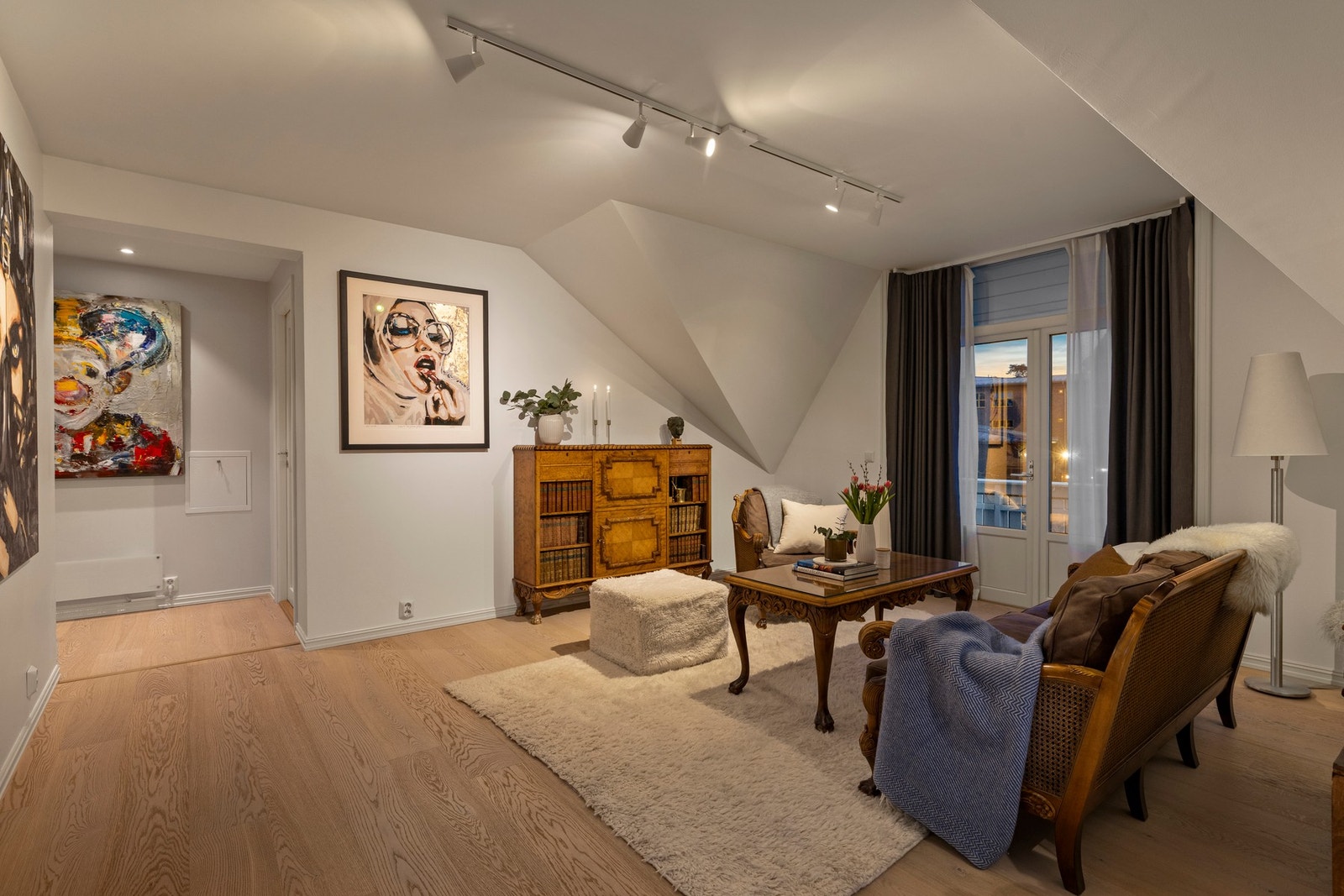 Stuen i leiligheten er romslig og flott opplyst med store vindusflater som gir rikelig med naturlig lys, og skaper en god atmosfære. Galleribilde