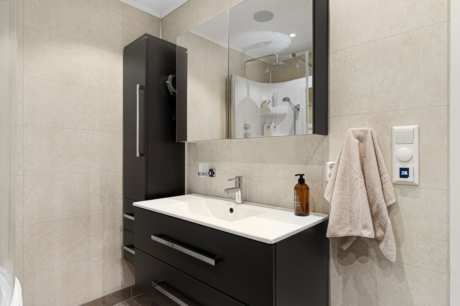 Mørk baderomsinnredning med god oppbevaringsplass. Galleribilde