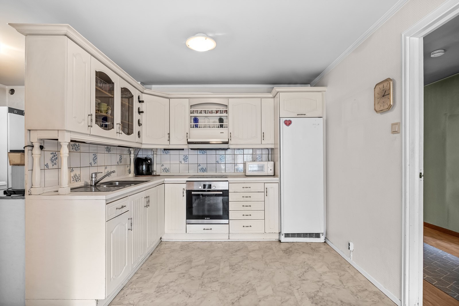 Romslig kjøkken med spiseplass og eldre kjøkkeninnredning. Galleribilde