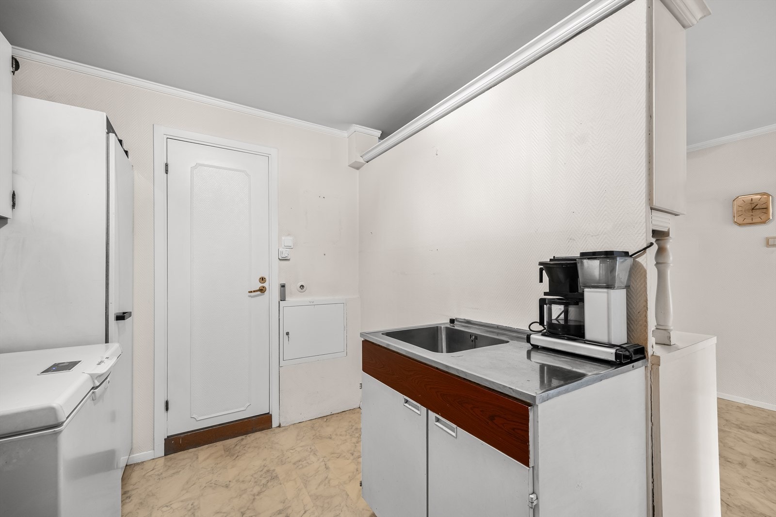 Funksjonelt grovkjøkken utstyrt med skap, utslagsvask og fryseskap. Rommet gir gode arbeidsforhold og ekstra lagringsplass, samt direkte inngang til boligens bad nr. 2. Galleribilde