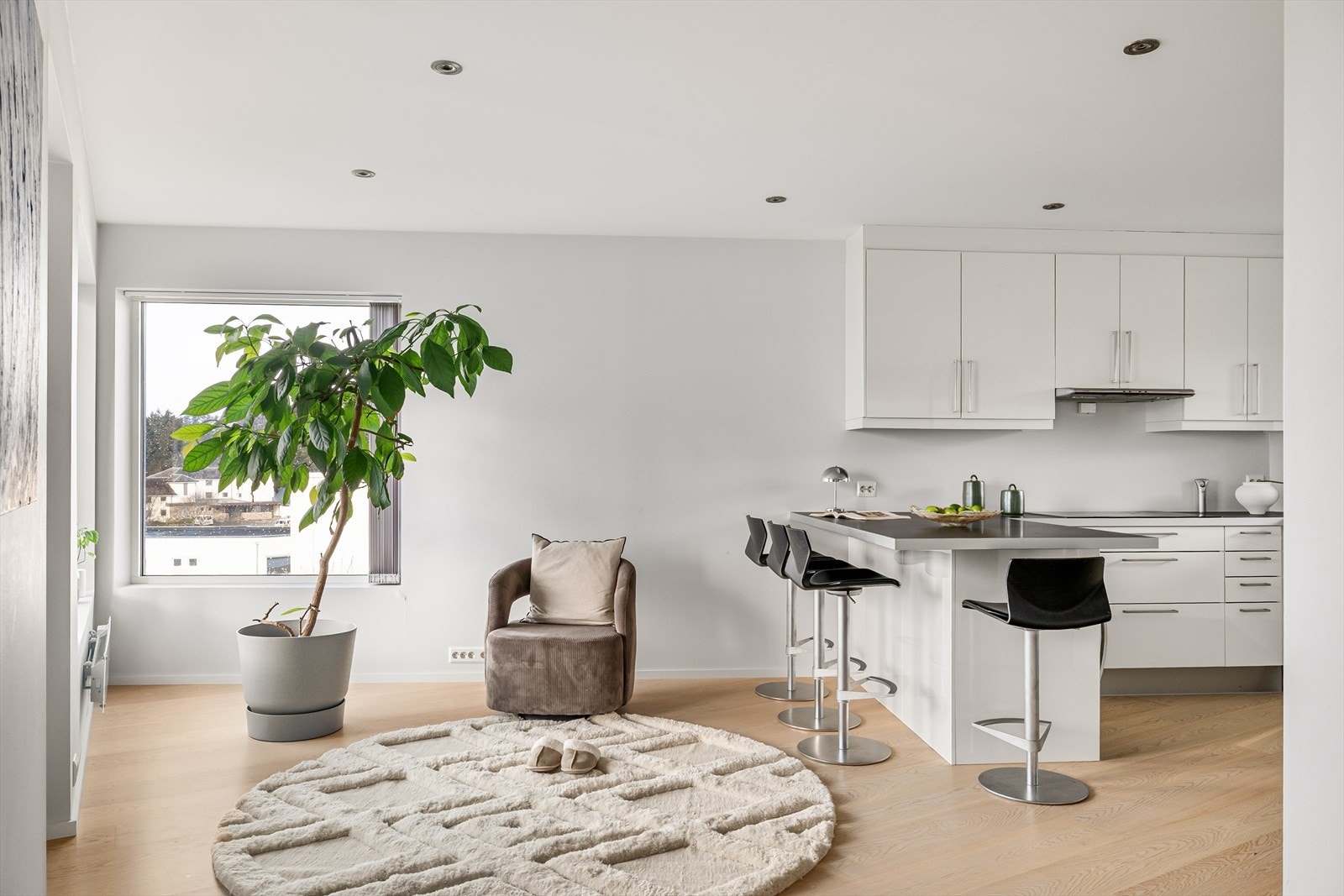 Kjøkkenet ligger i en egen sone adskilt fra stuen, og fremstår stilrent i hvit utførelse fra kvalitetsleverandøren Sigdal. Galleribilde