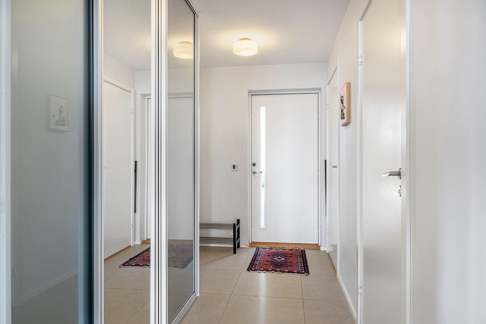 Lys og innbydende entré med flislagt gulv og skyvedørsgarderobe gir et godt førsteinntrykk. Galleribilde