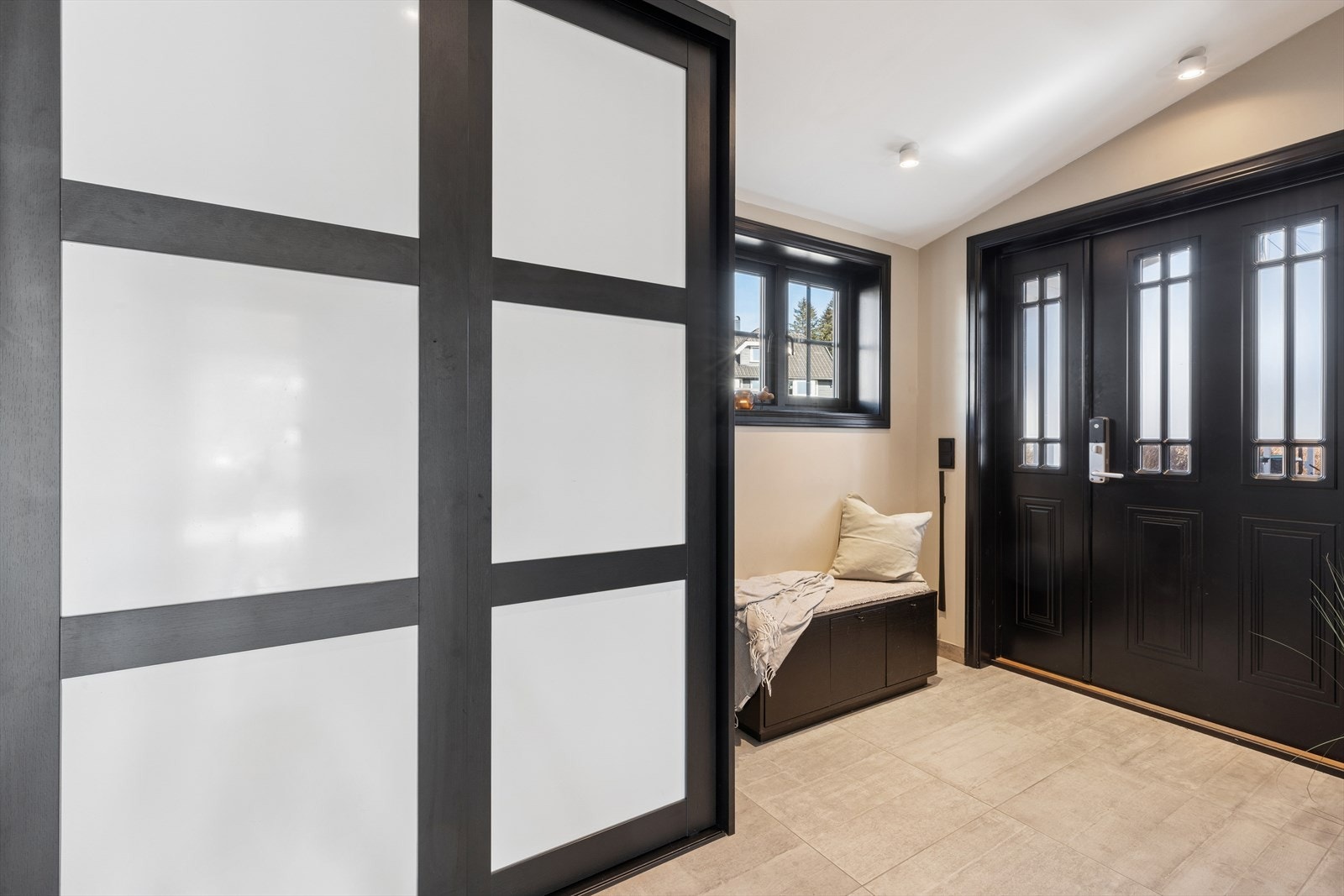 Entréen er innredet med skyvedørsgarderobe og har fliser på gulvet. Galleribilde