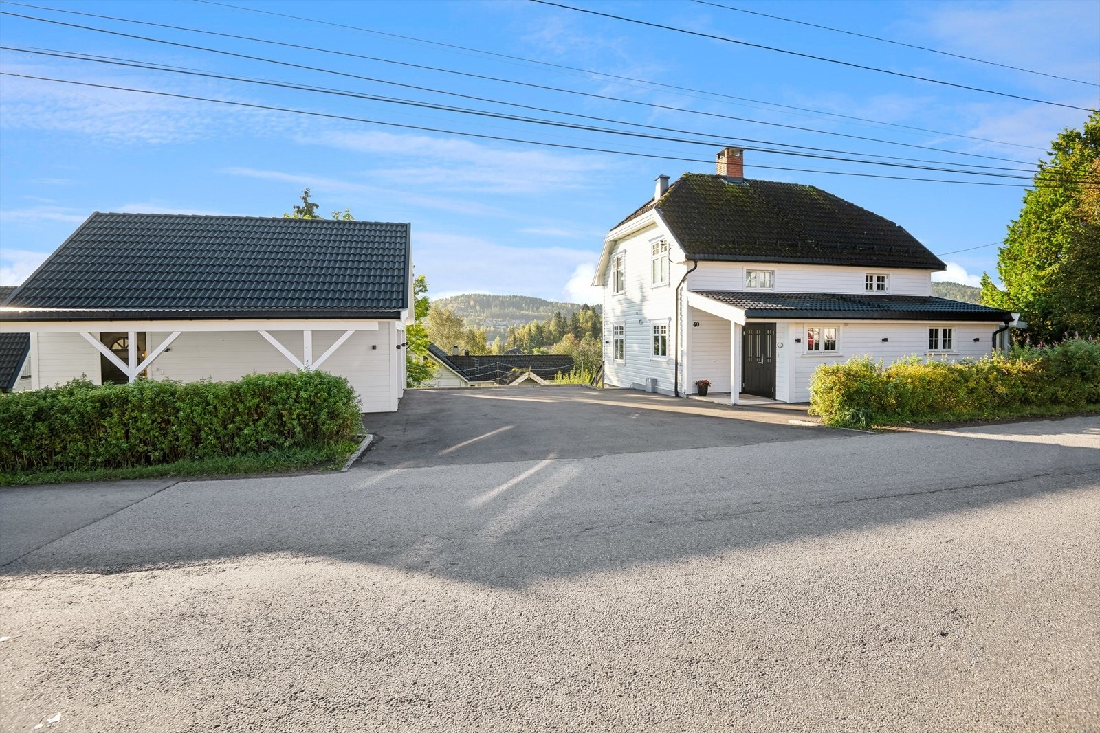 Tomten er pent opparbeidet med asfaltert innkjøring, gårdsplass med kantstein av granitt og en støpt høy støttemur mellom huset og garasjen. Galleribilde