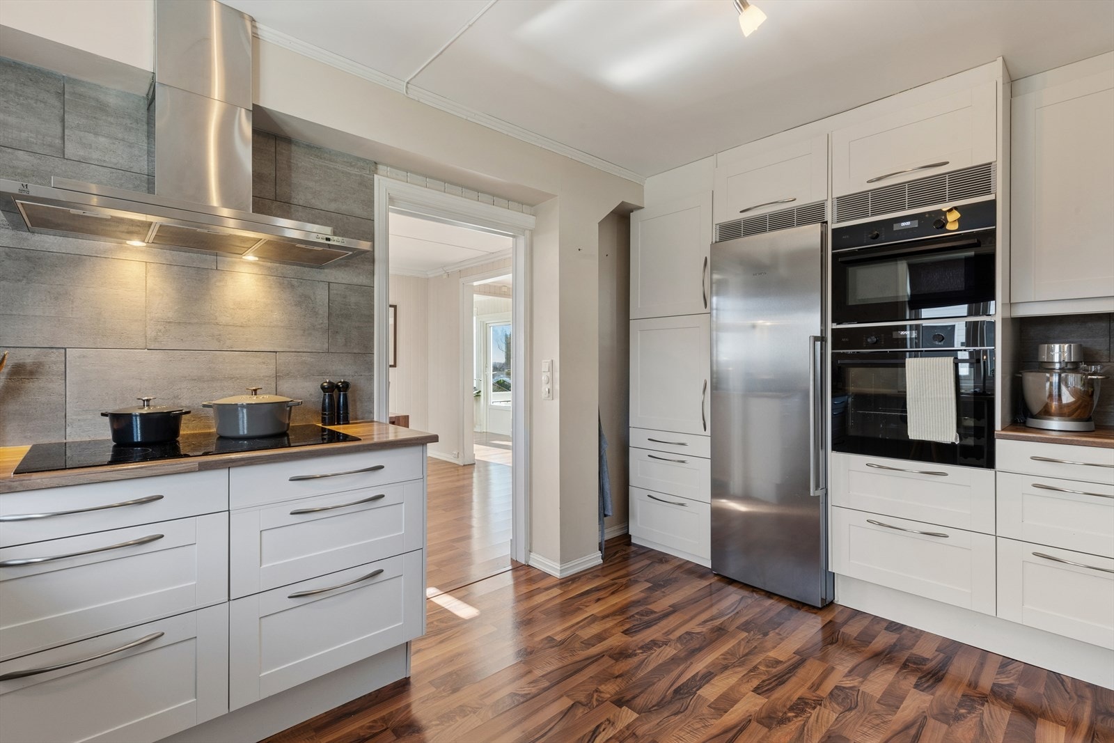 Kjøkkenet ble oppgradert i 2013 og har en pen innredning med hvite, profilerte fronter og laminert benkeplate med underlimt stålvask. Galleribilde