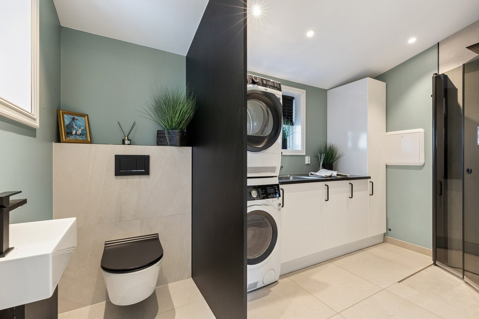 Det kombinerte baderommet og vaskerommet i 1.etasje er fra 2018 har flislagte overflater og varme i gulvet. Galleribilde