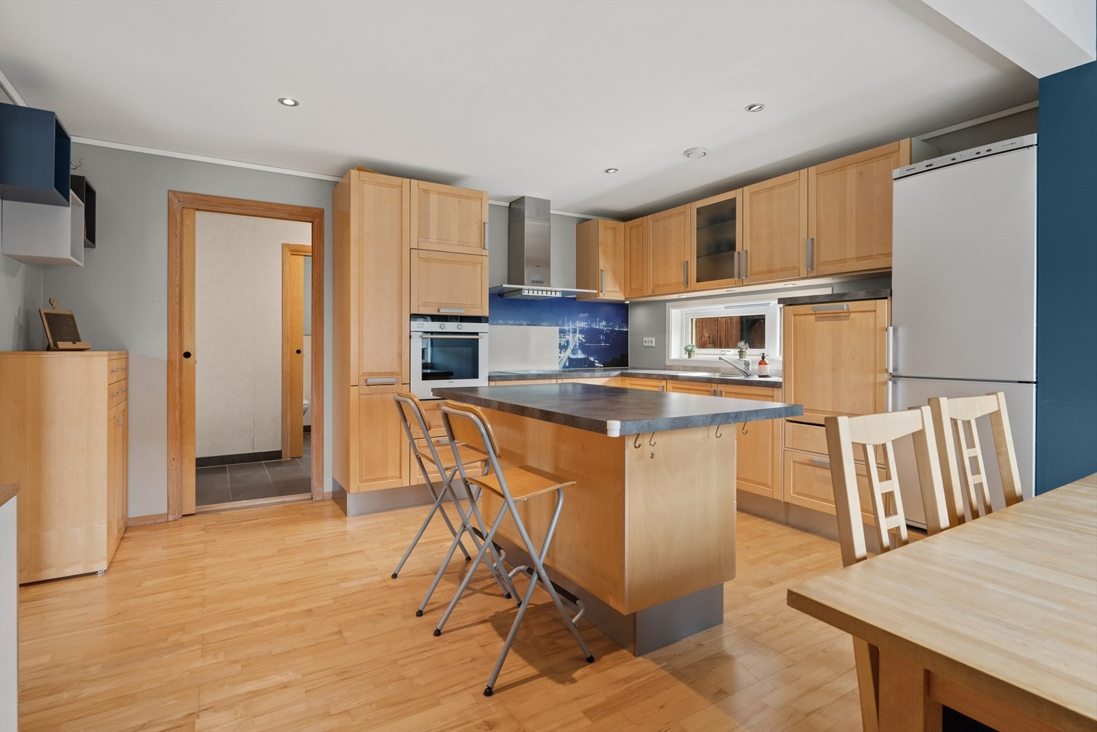 Kjøkkenet er levert av HTH og er innredet med trefargede, profilerte fronter og grå benkeplate i laminat. Et stort og godt kjøkken som gir godt med lagringsplass i skap og skuffer, samt gode arbeidsflater på en stor kjøkkenøy. Galleribilde