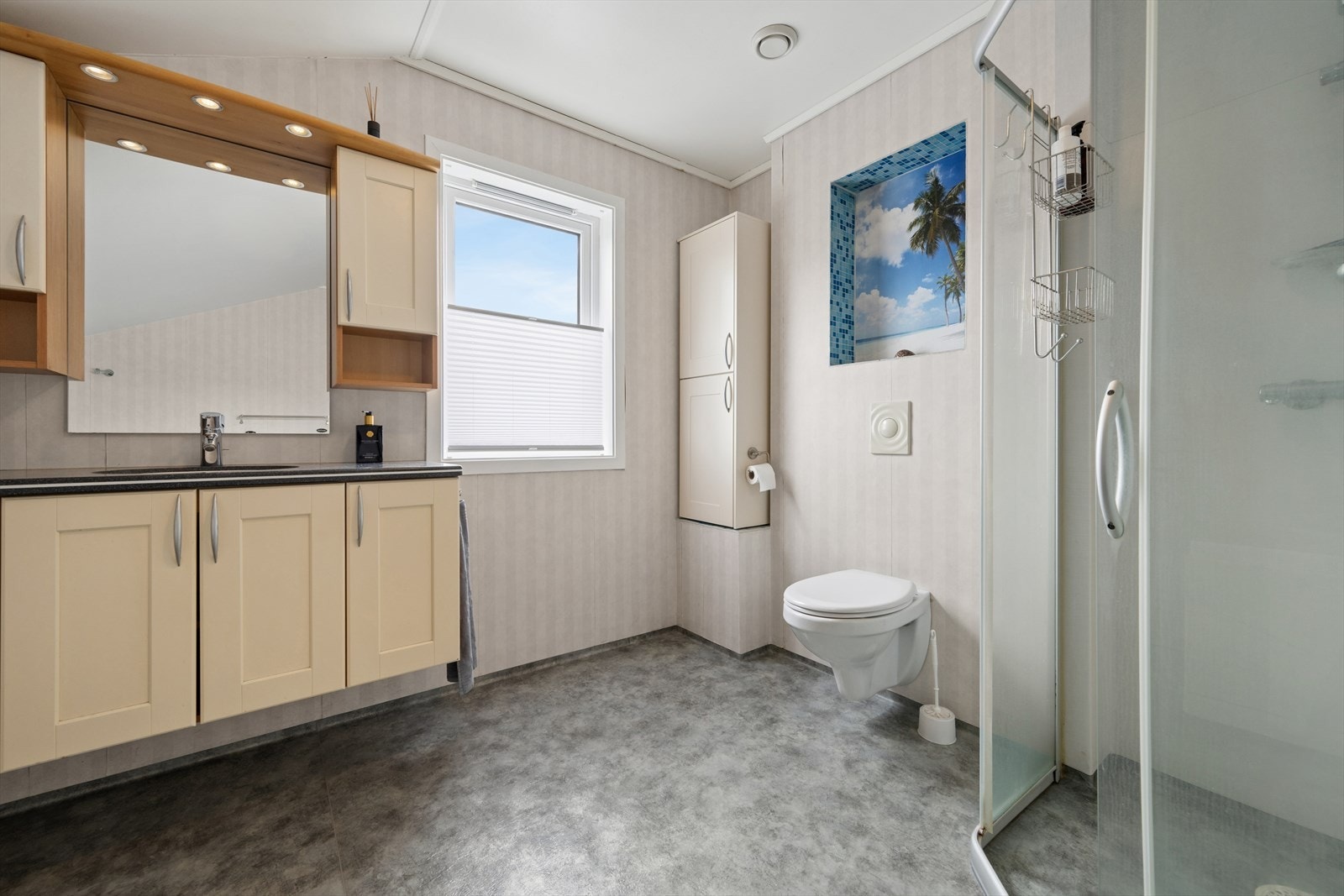 Baderommet i andre etasje er innredet med grått vinylbelegg på gulv og tapetserte veggflater. I gulvet har man også varmekabler for ekstra komfort. Galleribilde