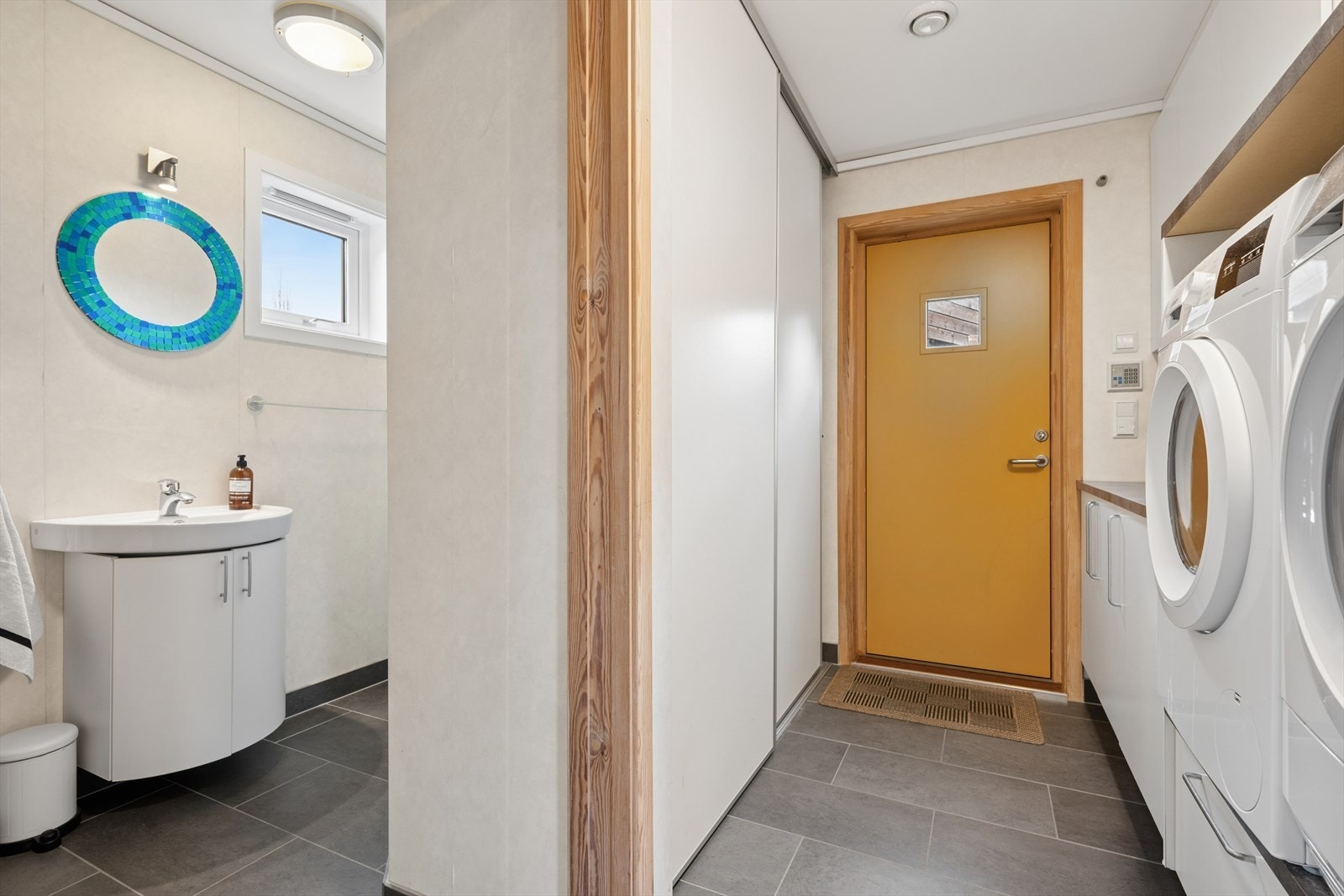 Boligen har også en praktisk bi-inngang, kombinert med vaskerom. Stor skyvedørsgarderobe sørger for god lagringsplass til familiens yttertøy. Ellers er rommet utstyrt med innredning som gir god lagringsplass og gode arbeidsflater på benk. Galleribilde