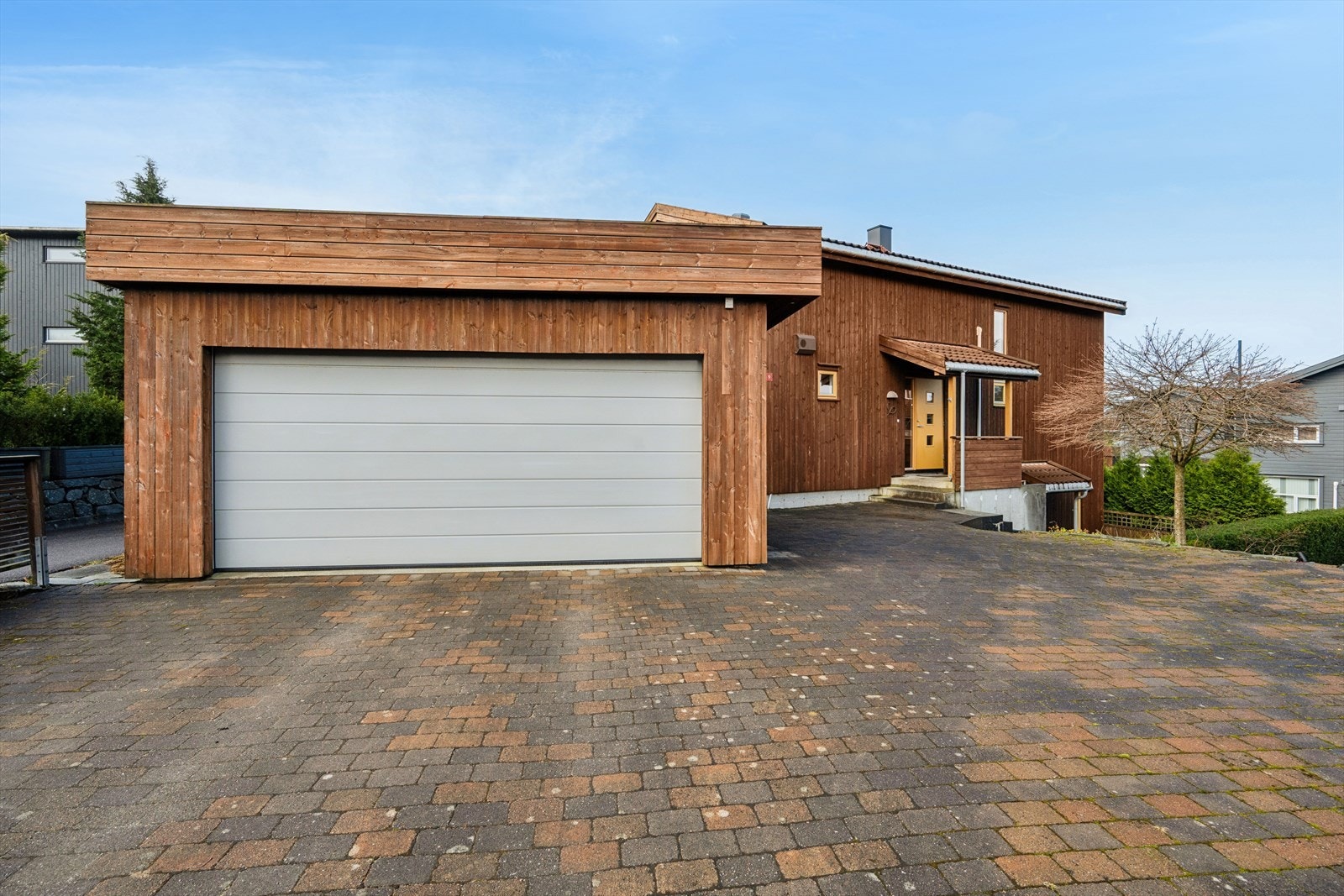 Gårdsrommet er pent opparbeidet med belegningsstein og har god plass til parkering av flere biler i tillegg til parkering i dobbel garasje med elbillader. Galleribilde