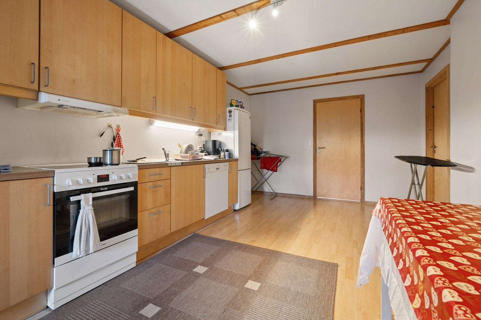 Kjøkkenet ligger i åpen løsning med stuen og er innredet med trefargede, slette fronter og trefarget benkeplate i laminat. Galleribilde