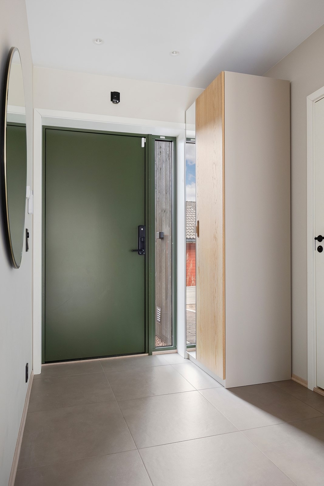 Velkommen inn i en lys entré med fliser på gulvet og innfelt LED-belysning i taket. Galleribilde