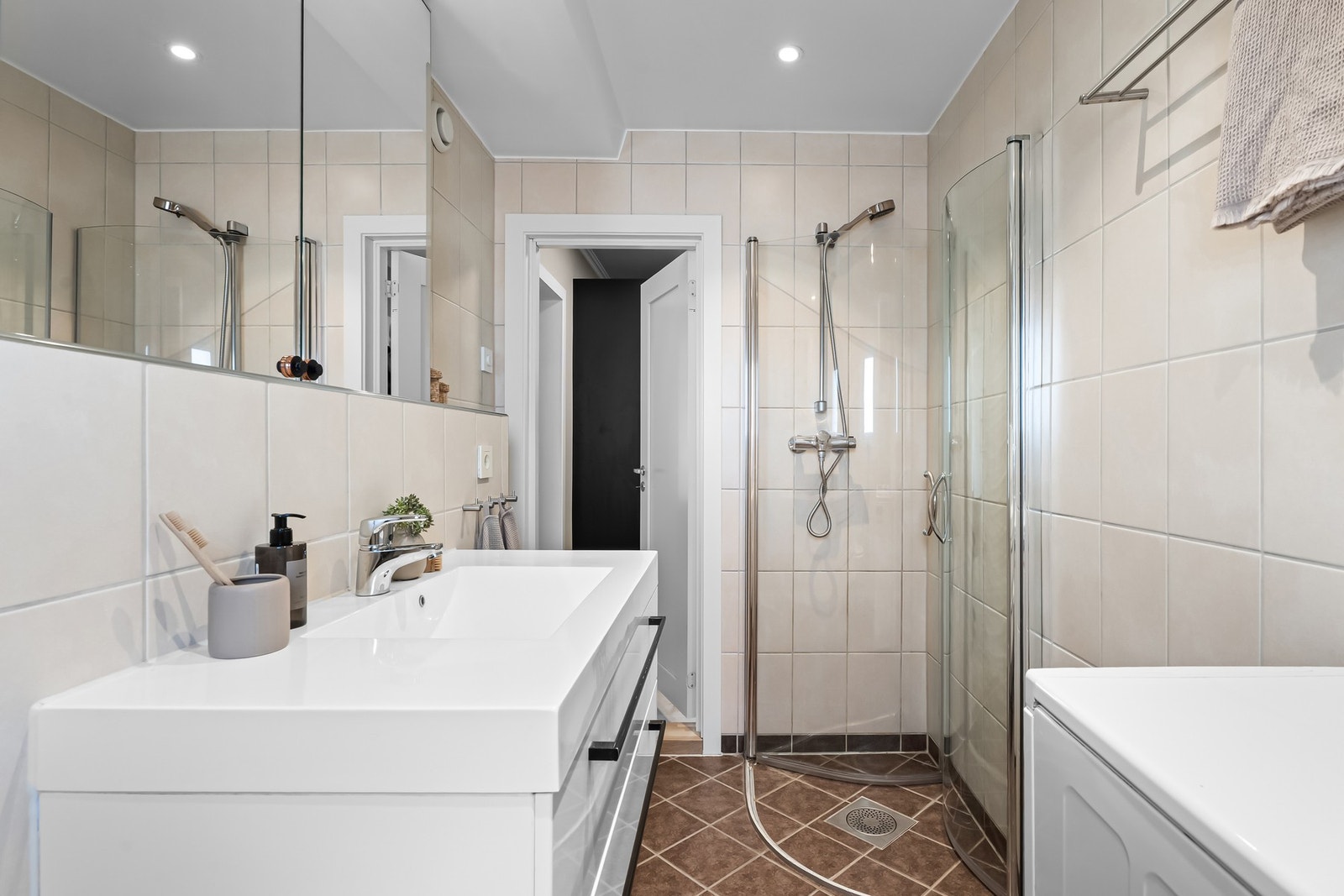 Badet er innredet med dusjkabinett, toalett og servantskap med heldekkende servant, samt opplegg for vaskemaskin, som var ny i 2025. Galleribilde