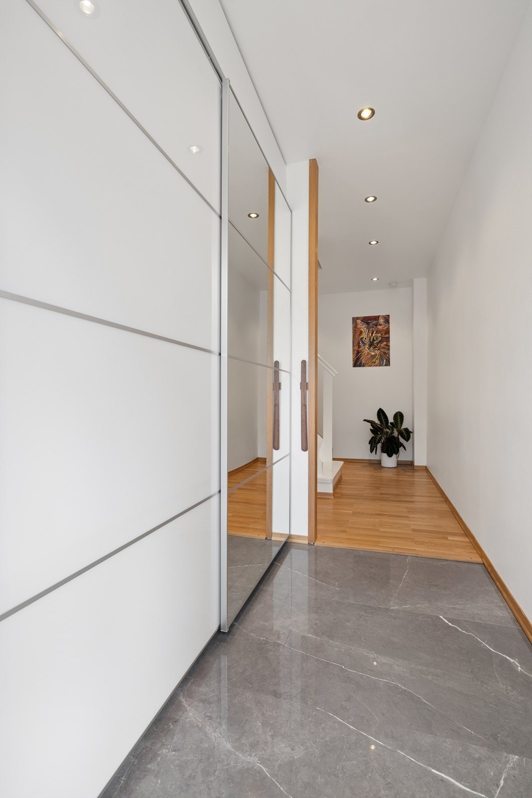 Velkommen inn i en lys og pen entré med stor skyvedørsgarderobe og elektriske varmekabler i gulvet Galleribilde