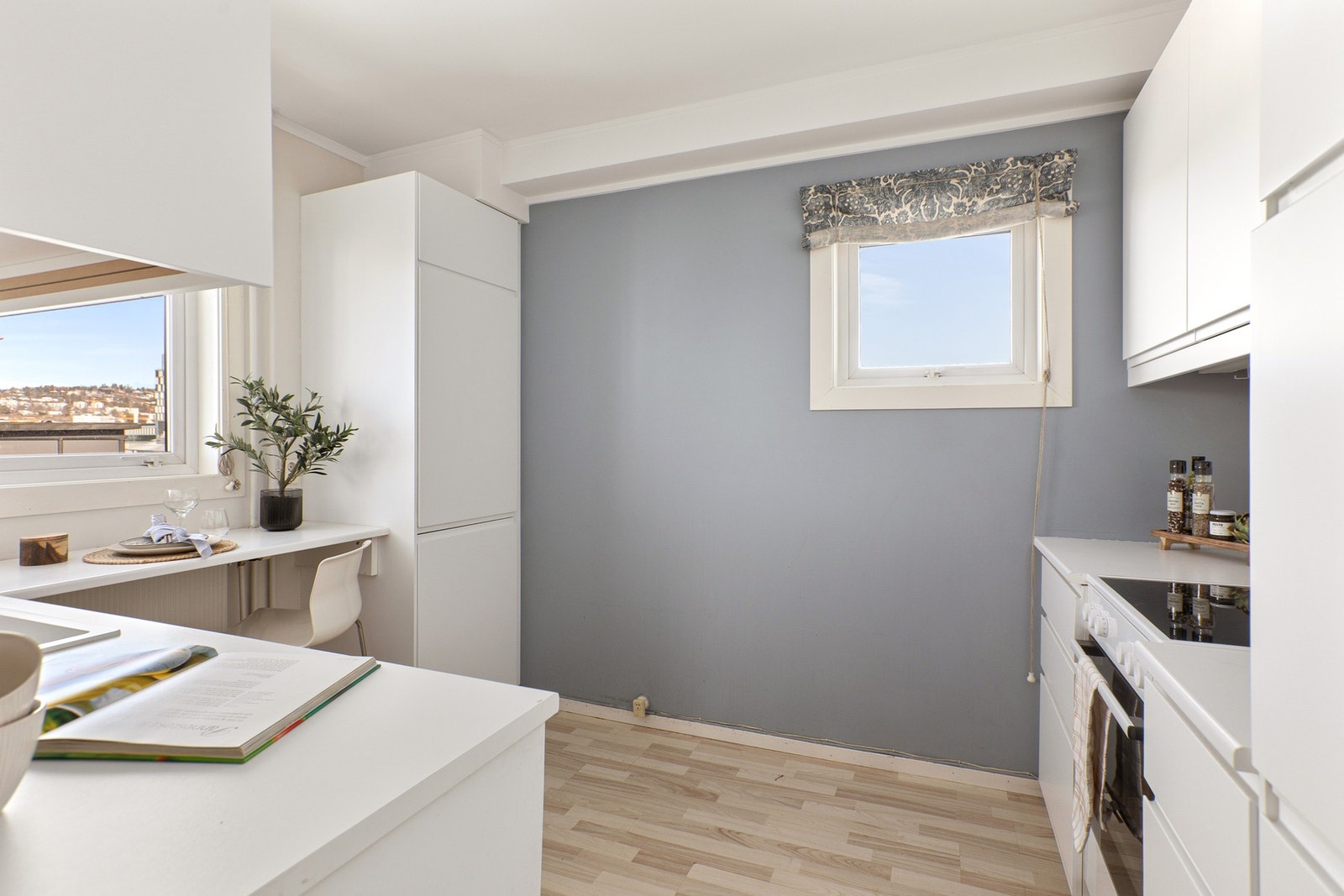 Kjøkken fra IKEA i eget rom, med glatte fronter og laminert benkeplate med nedfelt oppvaskkum. Galleribilde