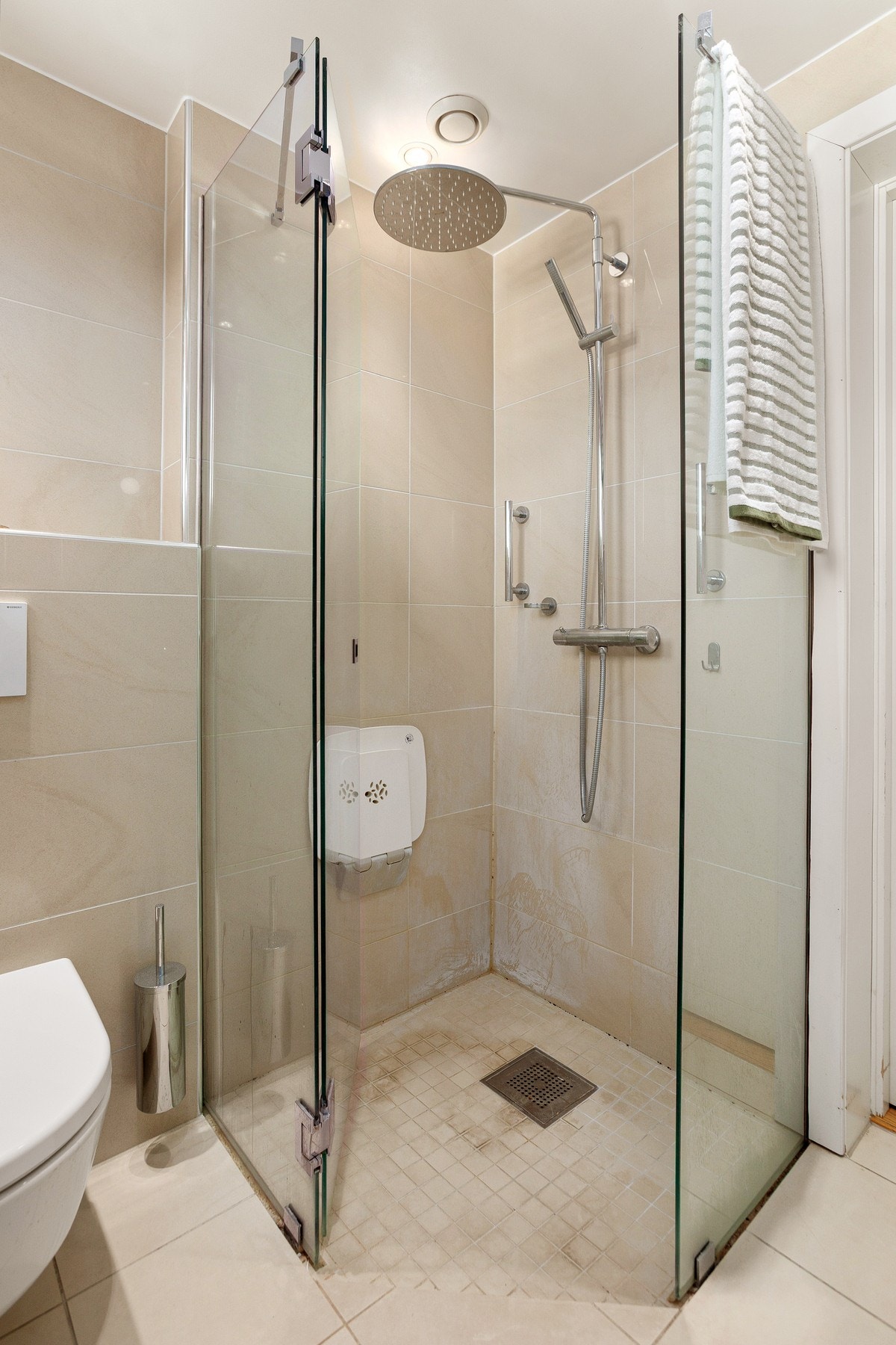 Badet er funksjonelt innredet med servant med underskuffer, speilskap, toalett og dusjhjørne med innfellbare glassvegger. Galleribilde