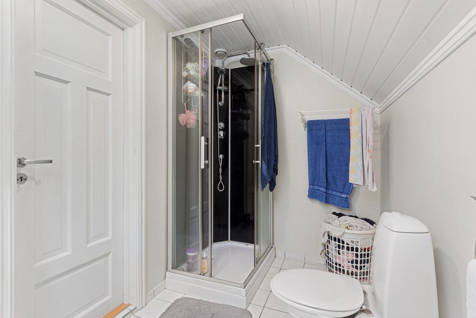 Badet er innredet med servanti i innredning med skap, dusjkabinett og toalett. Det er opplegg til vaskemaskin i innvendig bod som ligger vegg-i-vegg med badet Galleribilde