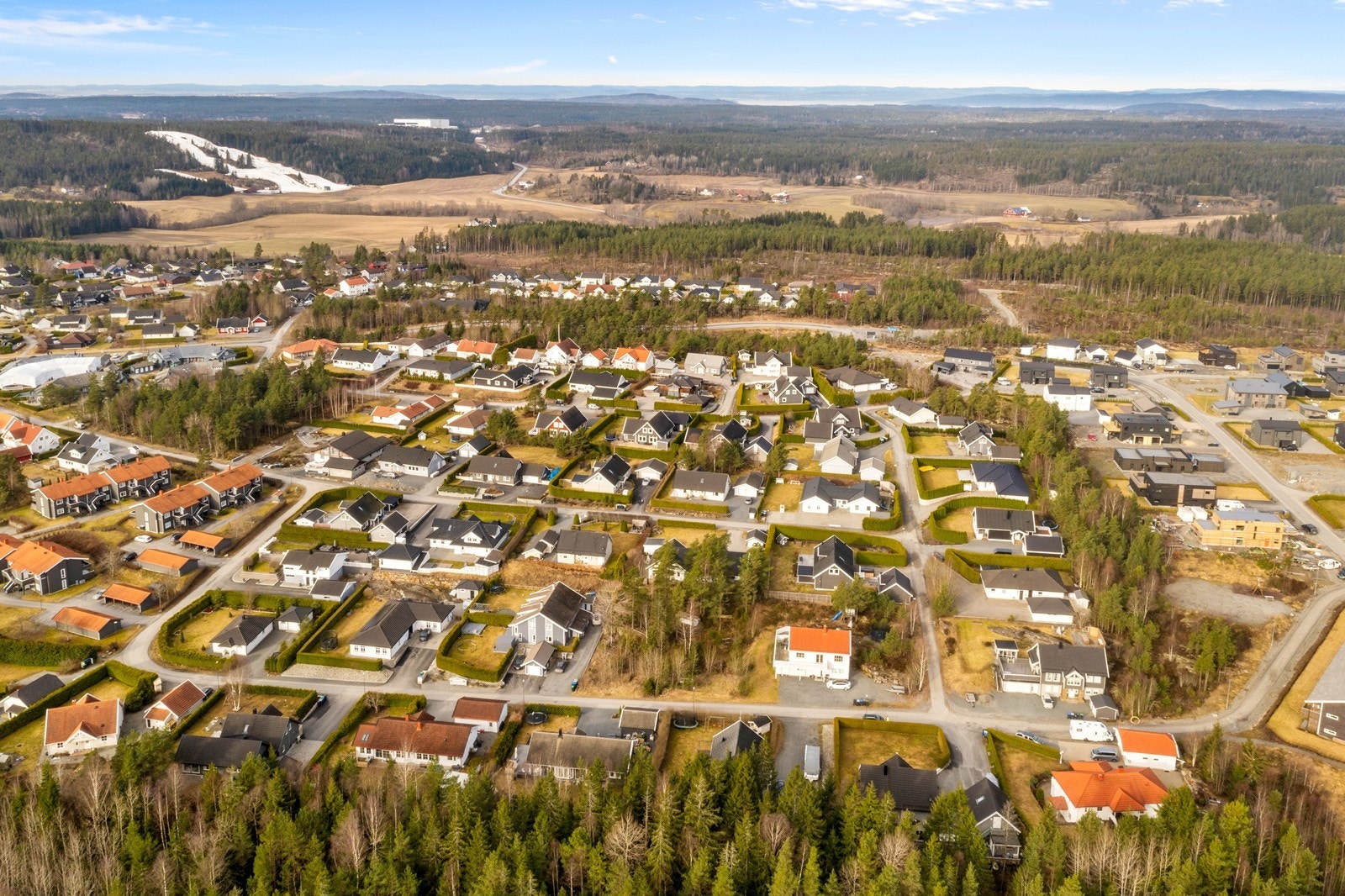 Vidstrakt utsikt over nærområdet, som kombinerer etablerte boligfelt med landlige omgivelser. Galleribilde