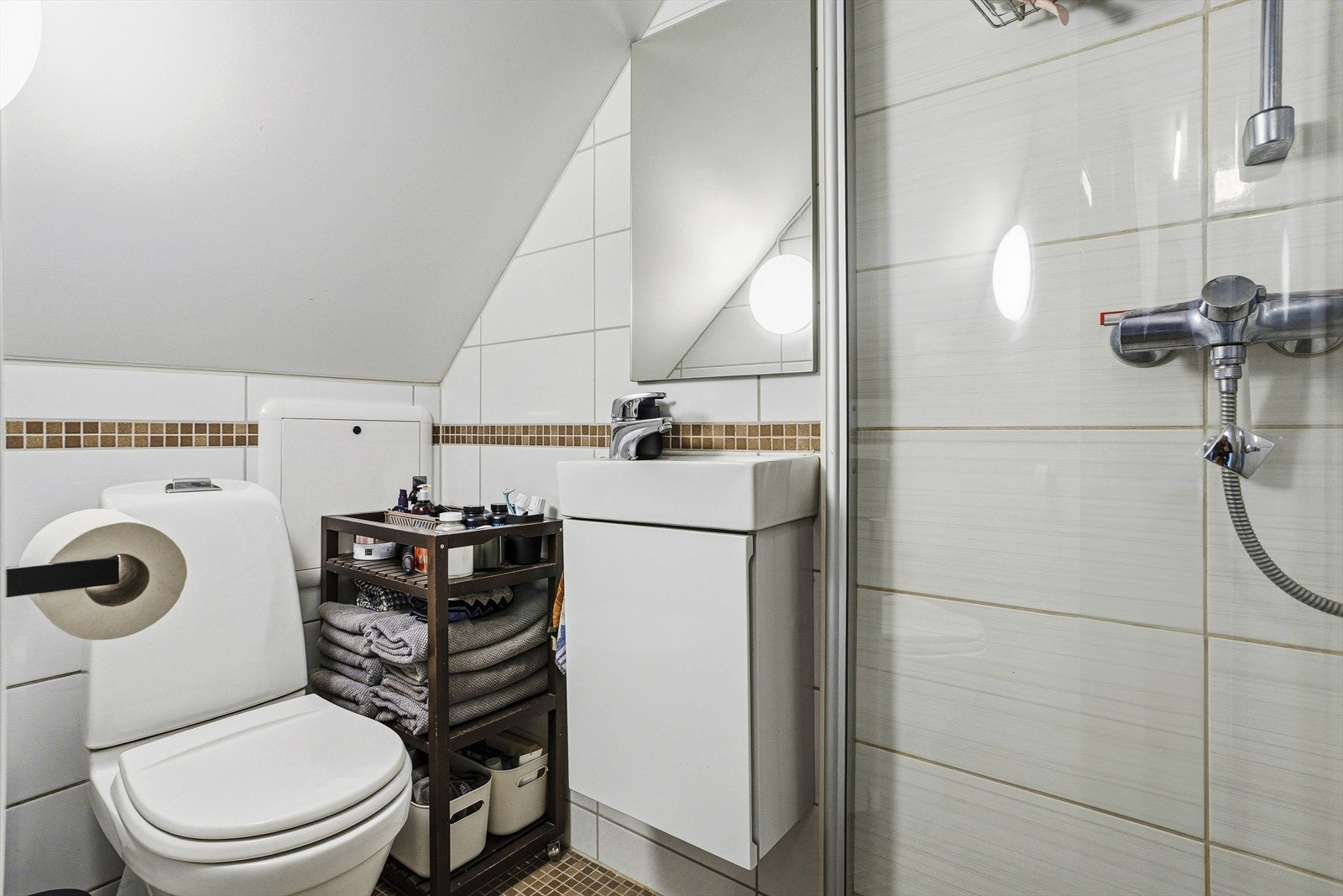 Rommet er innredet med toalett, vask med underskap og dusj. Varme i gulvet. Galleribilde